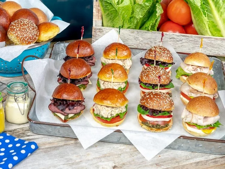 Assorted mini sliders with meat and vegetable fillings arranged on a serving platter