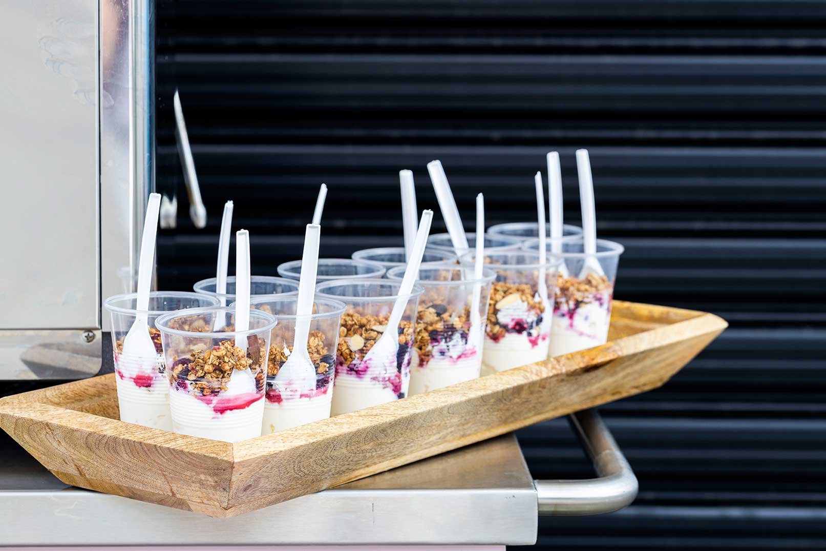 Yoghurt and muesli cups with granola, on a wooden tray