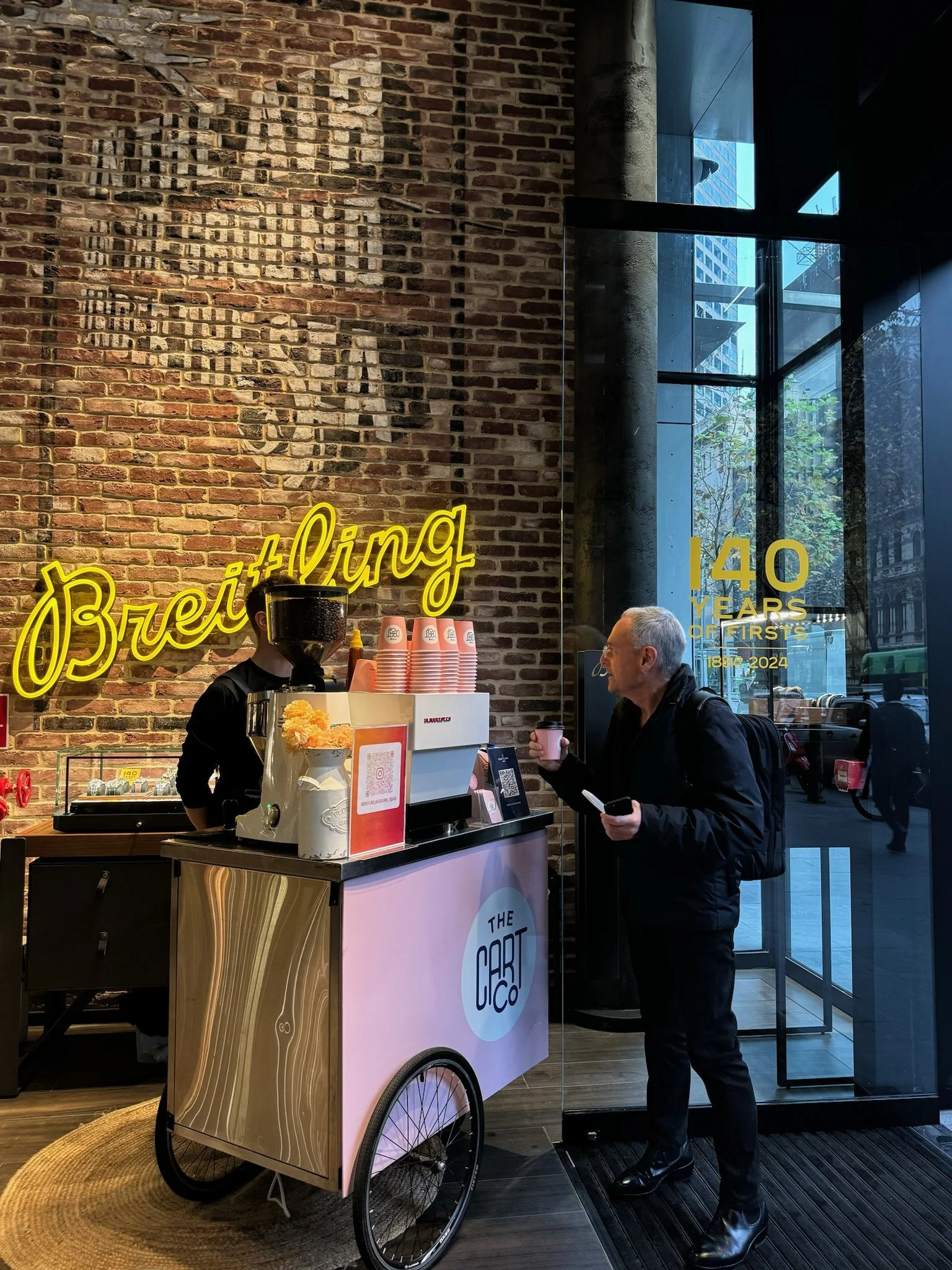 The Cart Co coffee cart with a guest beside it at an indoor event