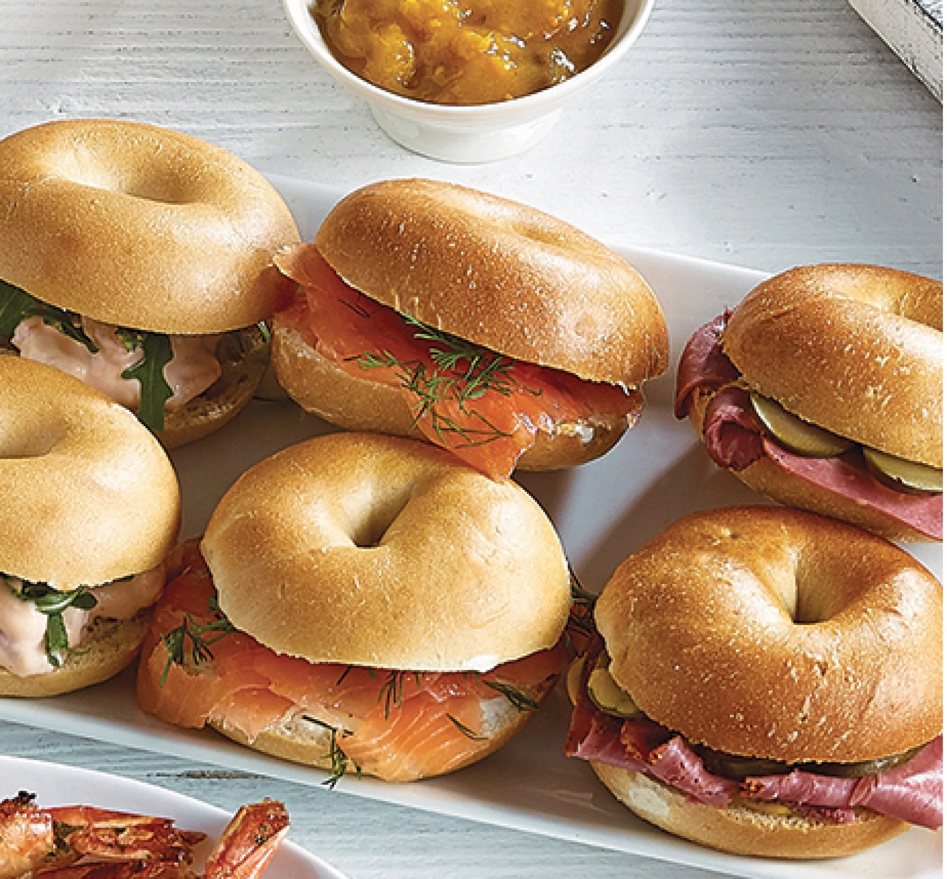 Assorted mini bagels filled with smoked salmon, sliced meats and greens