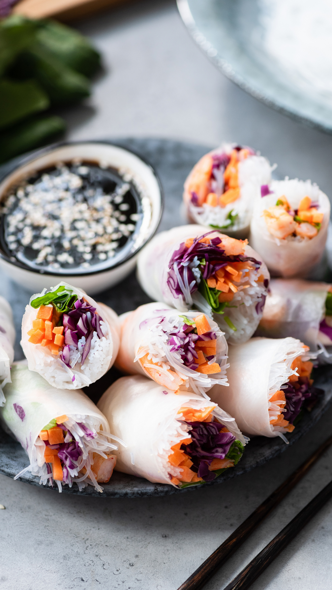 Rice paper rolls filled with fresh vegetables and rice noodles alongside a dipping sauce