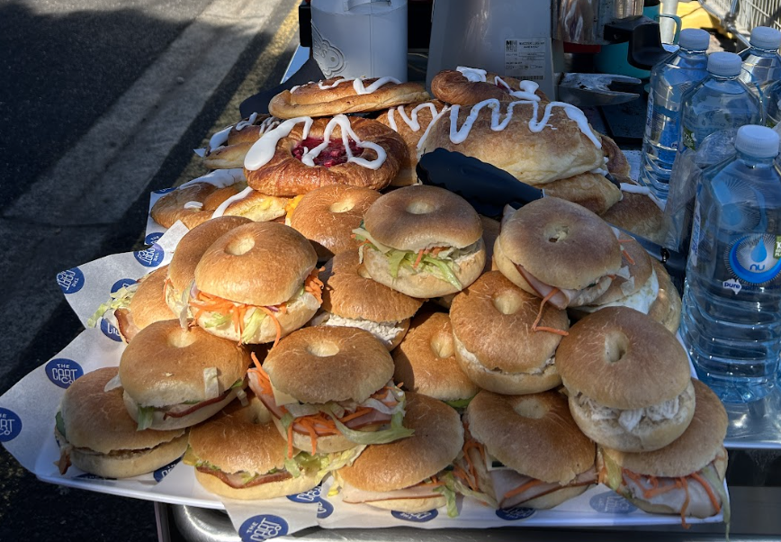 Mini bagel sandwiches with salad fillings arranged on a branded serving tray