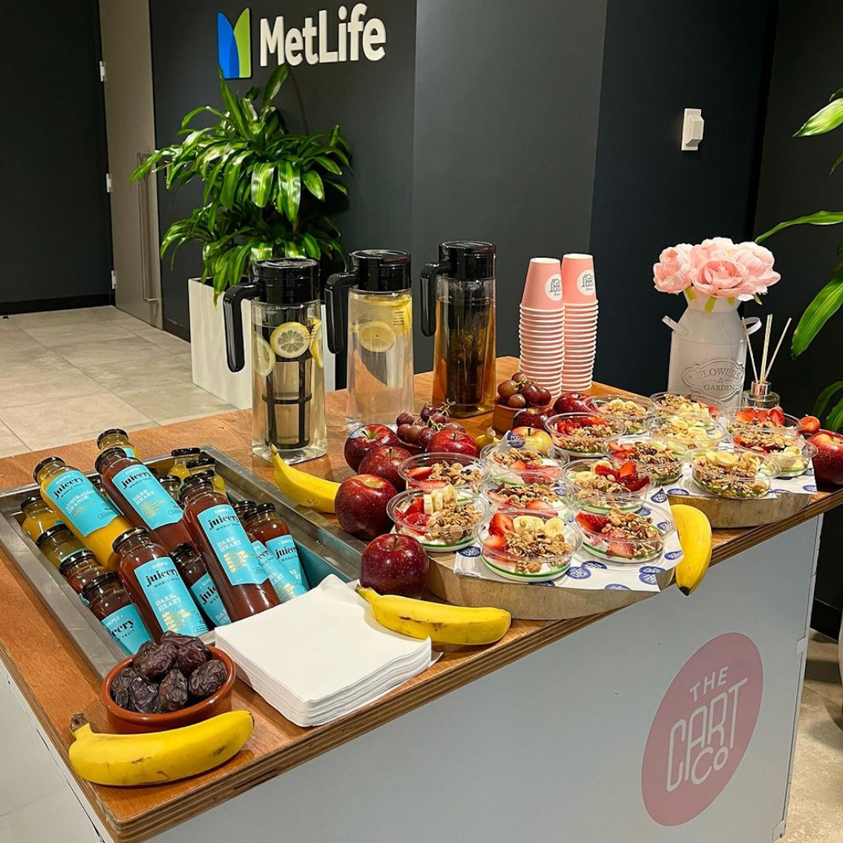 The Cart Co wellness cart displaying fruit, yoghurt bowls, bottled juices and infused water