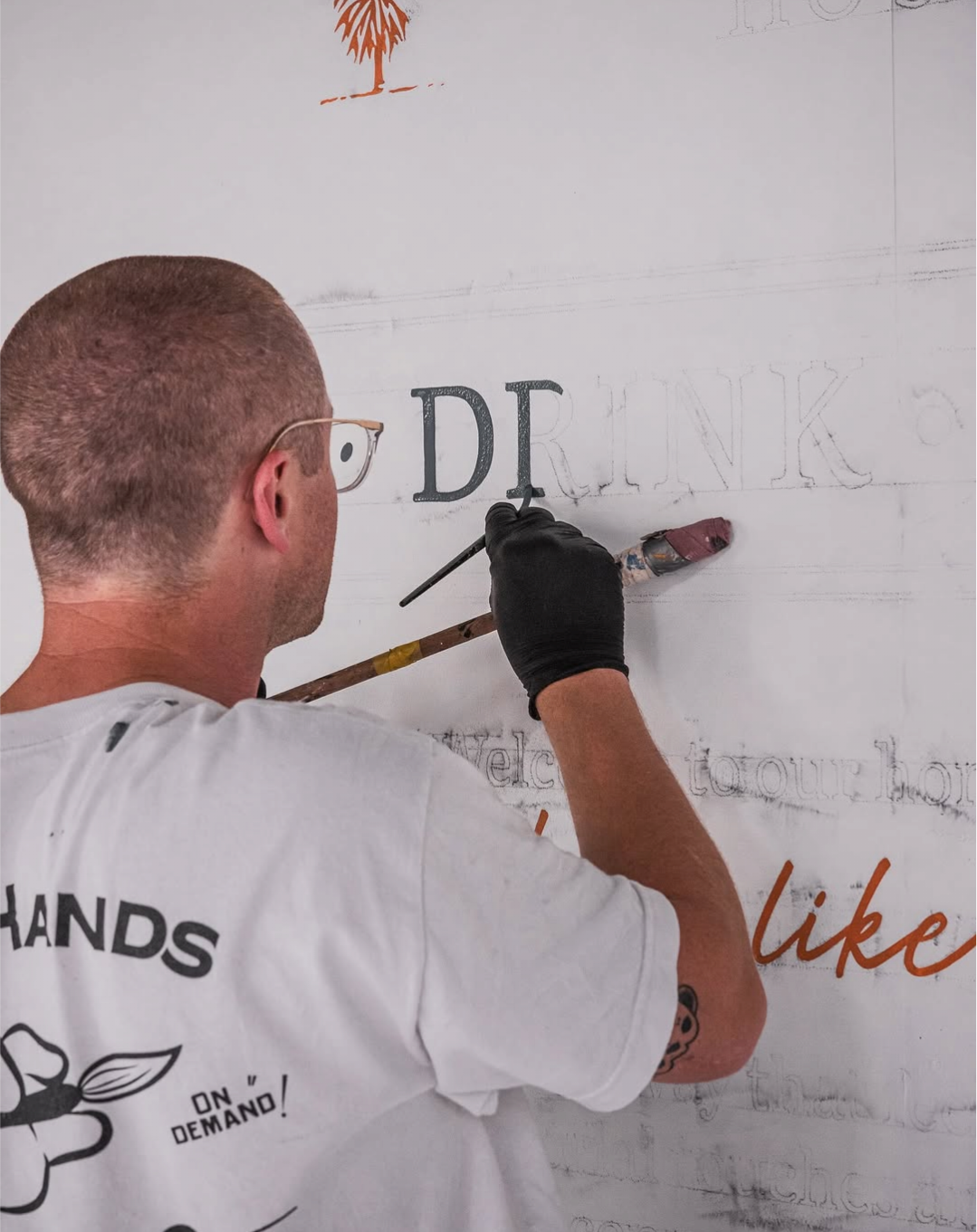 IMAGE OF THE OWNER PAINTING A SIGN