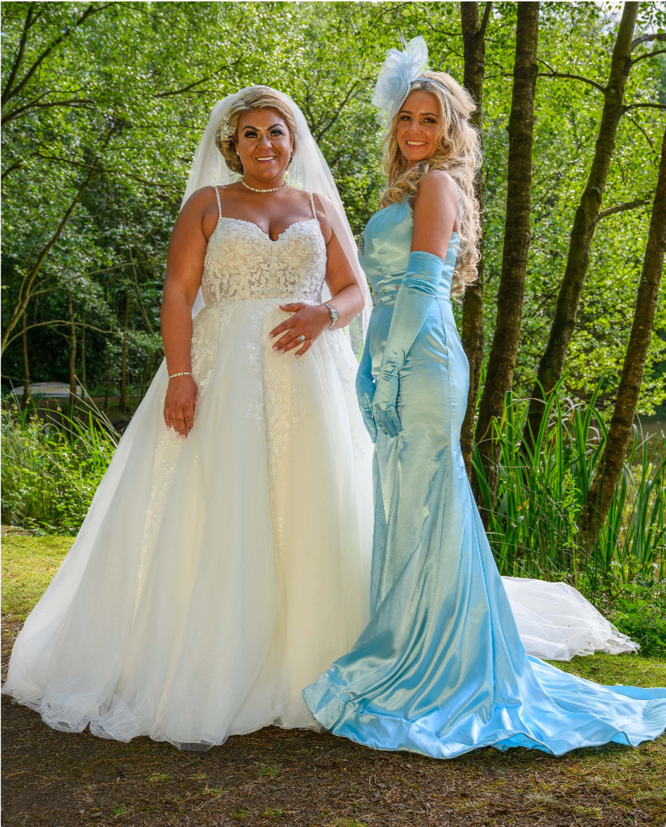 Candid wedding photography in Yorkshire. Bride in white dress. Chief Maid wearing long blue dress. Photograph in natural green surroundings.