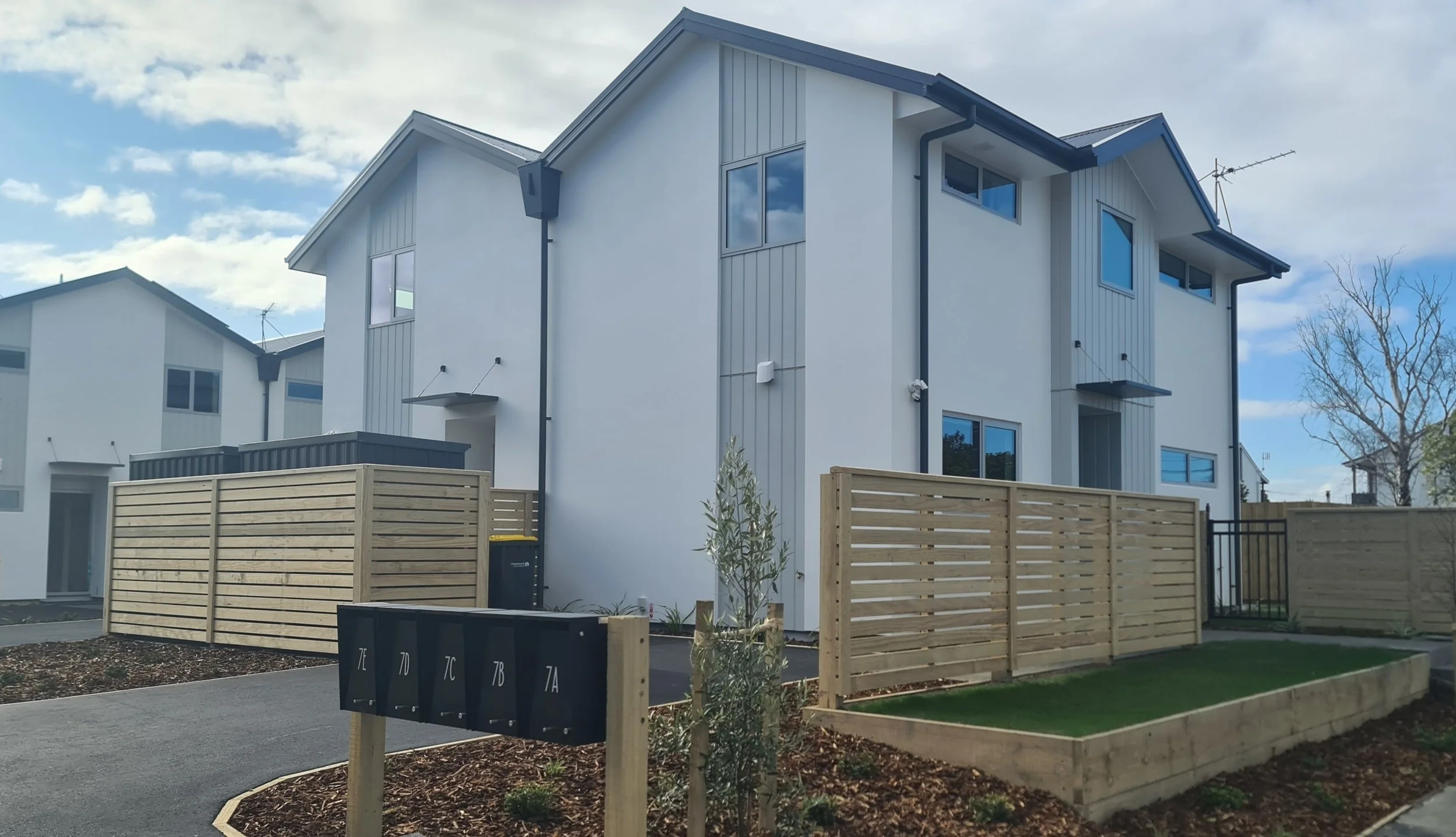 Two-level dwellings with street frontage, fencing and garden areas.
