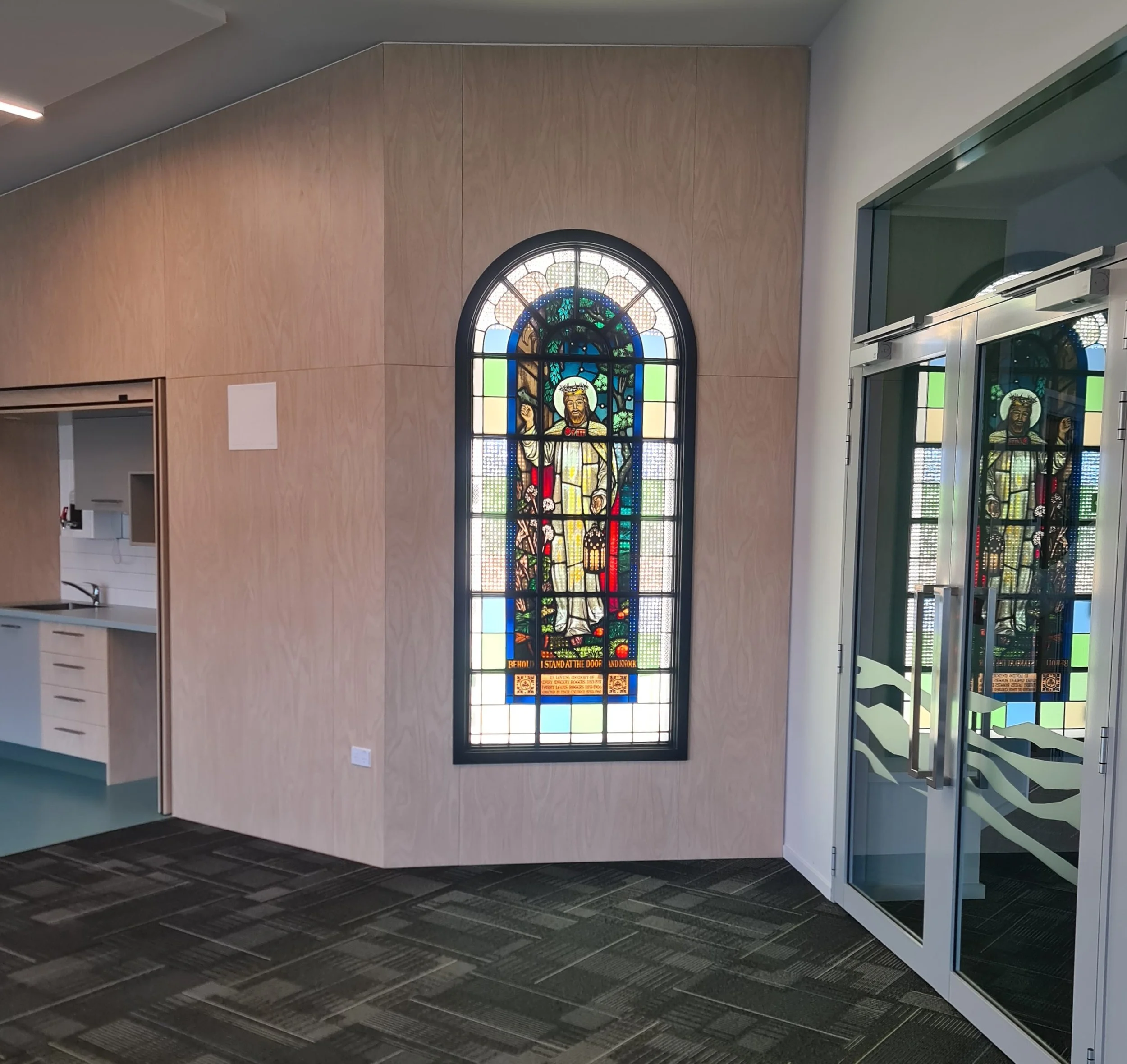 Foyer area of Jon Knox Church with stained glass window before entrance to church auditorium
