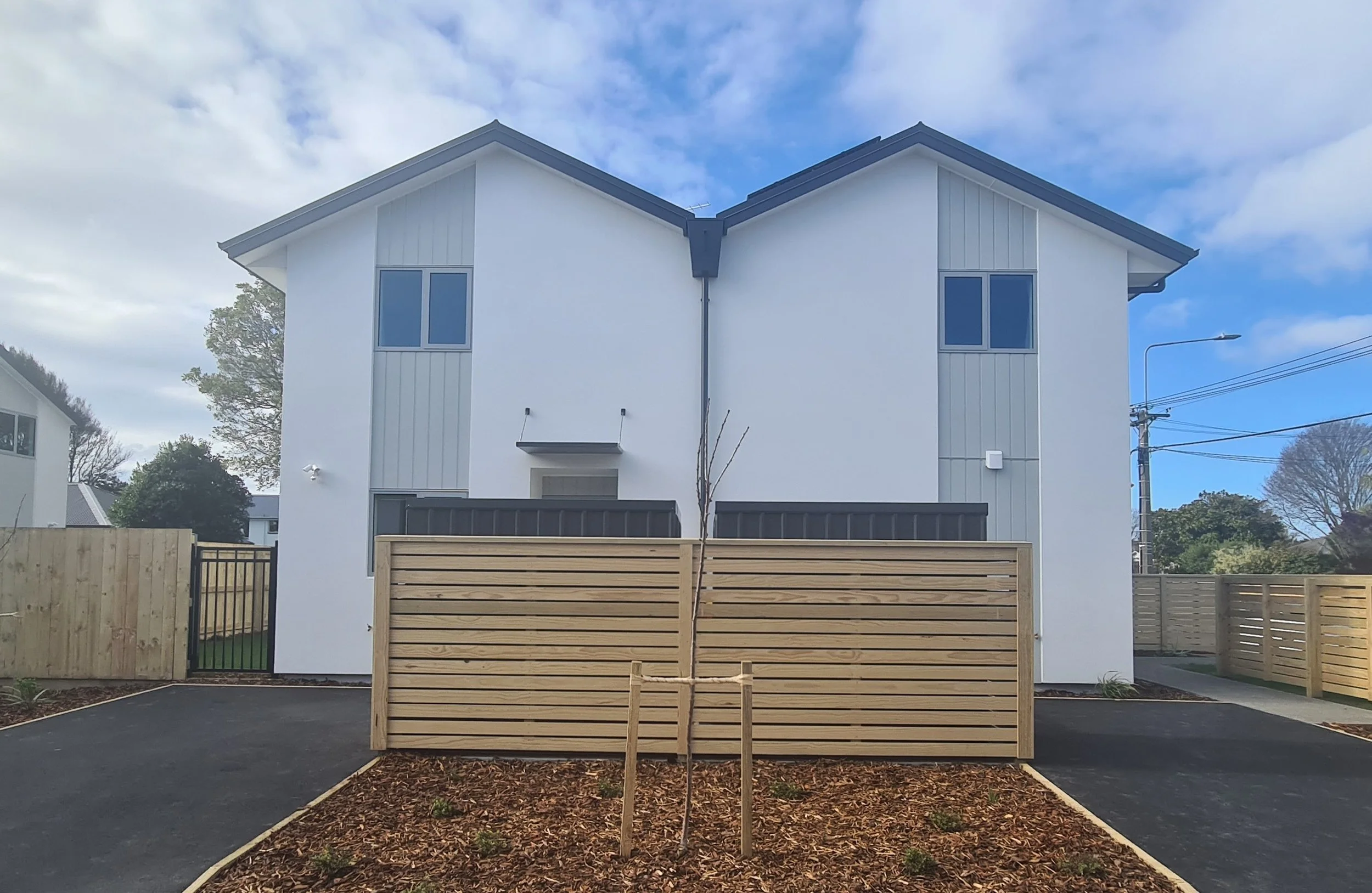 Two-level homes with fencing, planting and paved access and parking areas