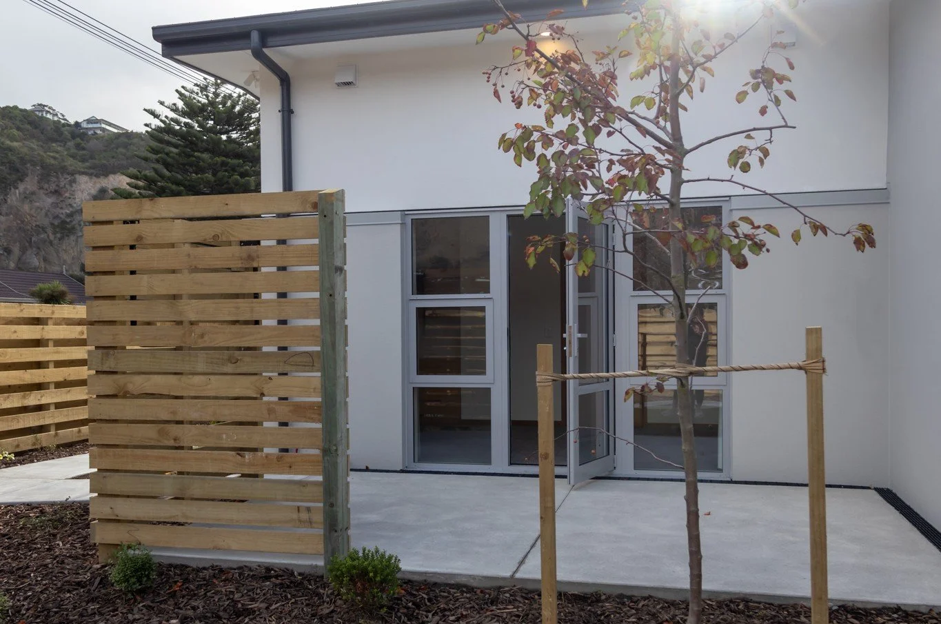 Private paved area accessed from lounge with fencing and planting