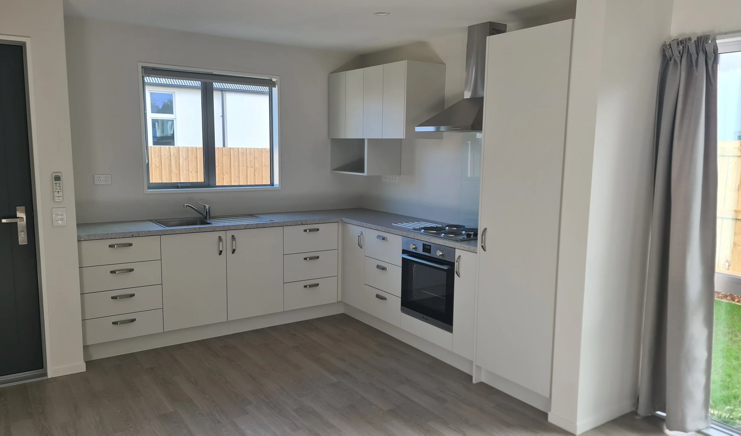 Kitchen area with laminate timber-look flooring, door and windows