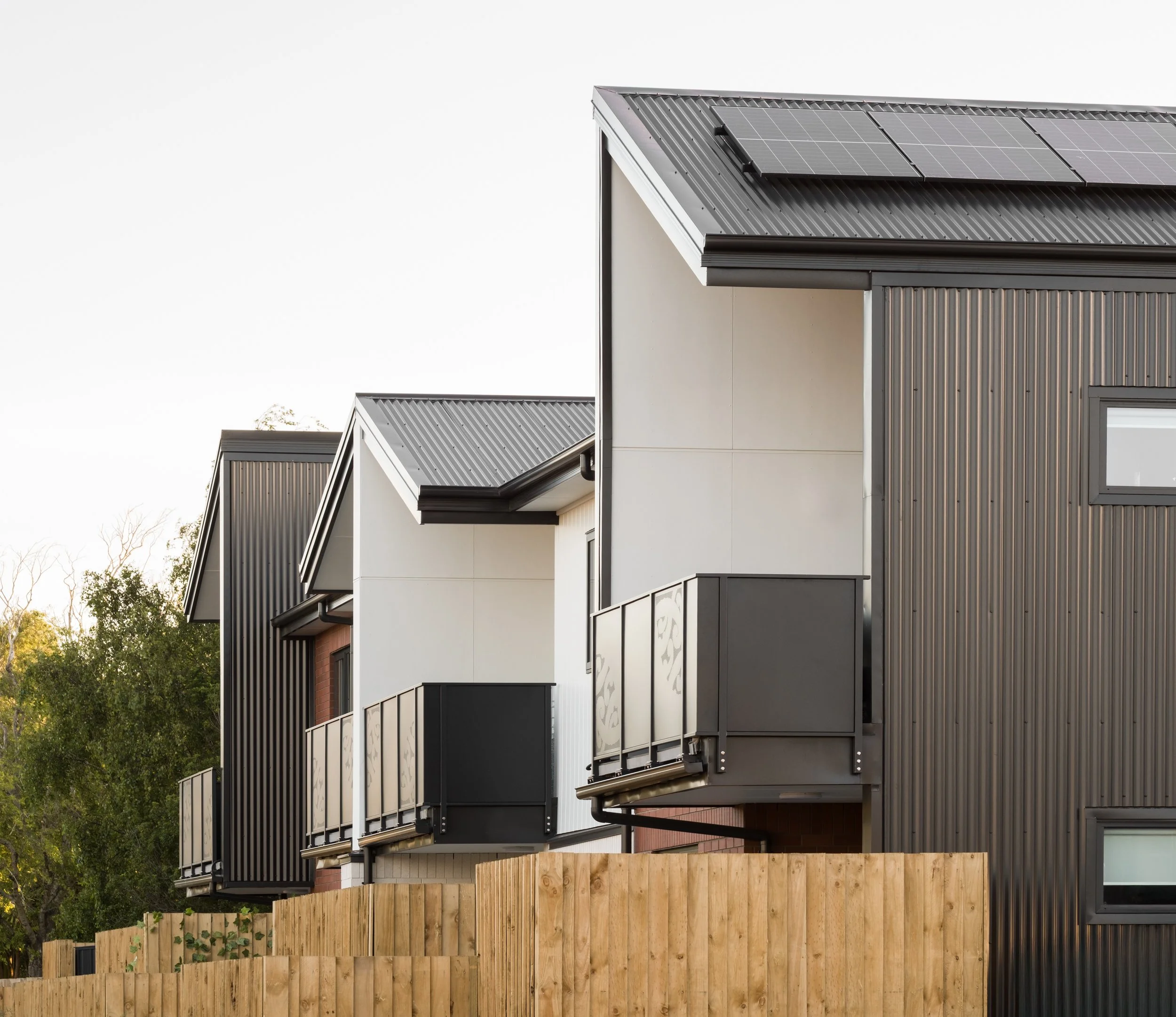 Second level with balconies and solar panels on roof within Three Lanes housing developement