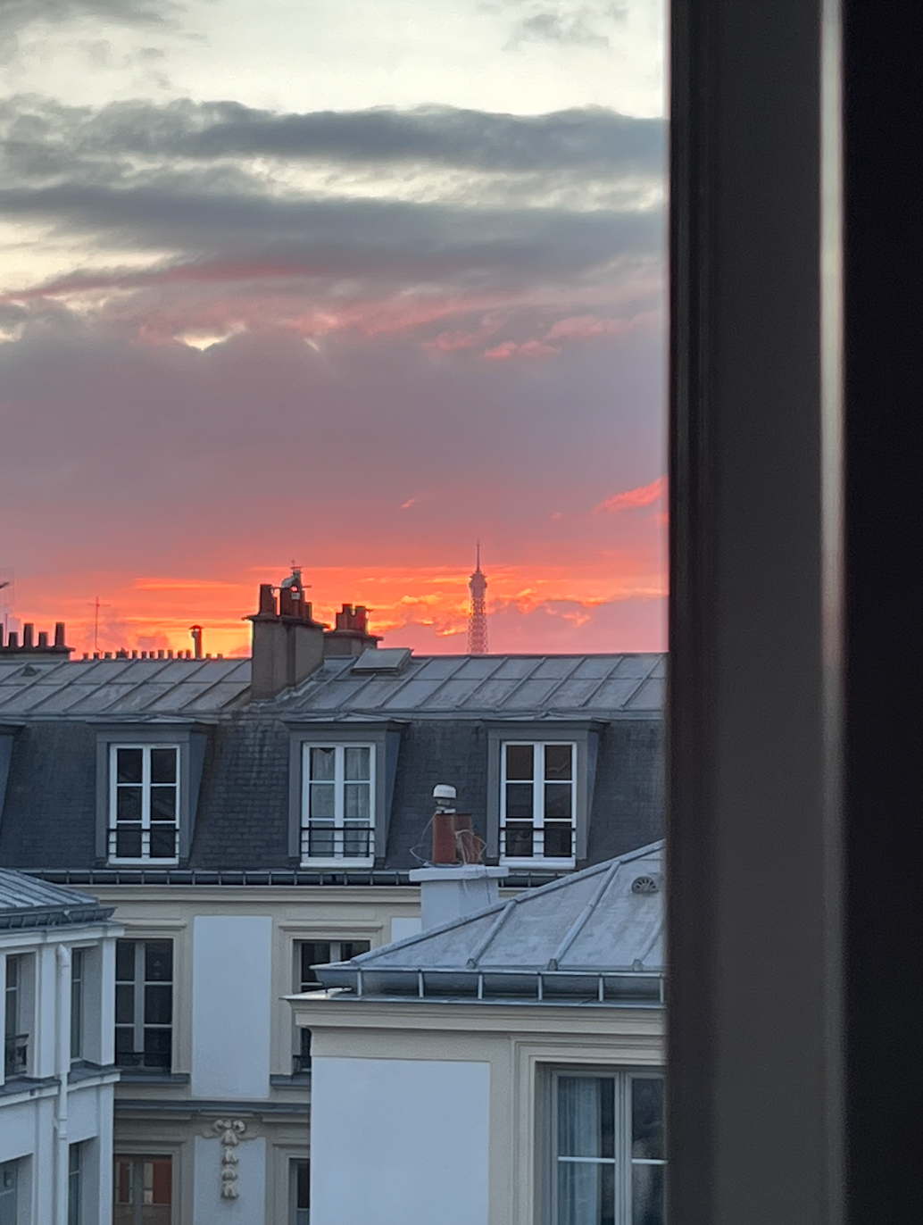 Petite Paris Studio Francois - the ultimate writers apartment in the 6eme st germain des pres, on the seine river, a rustic artists space with writers desk at the window overlooking a rooftop and eiffel tower view.