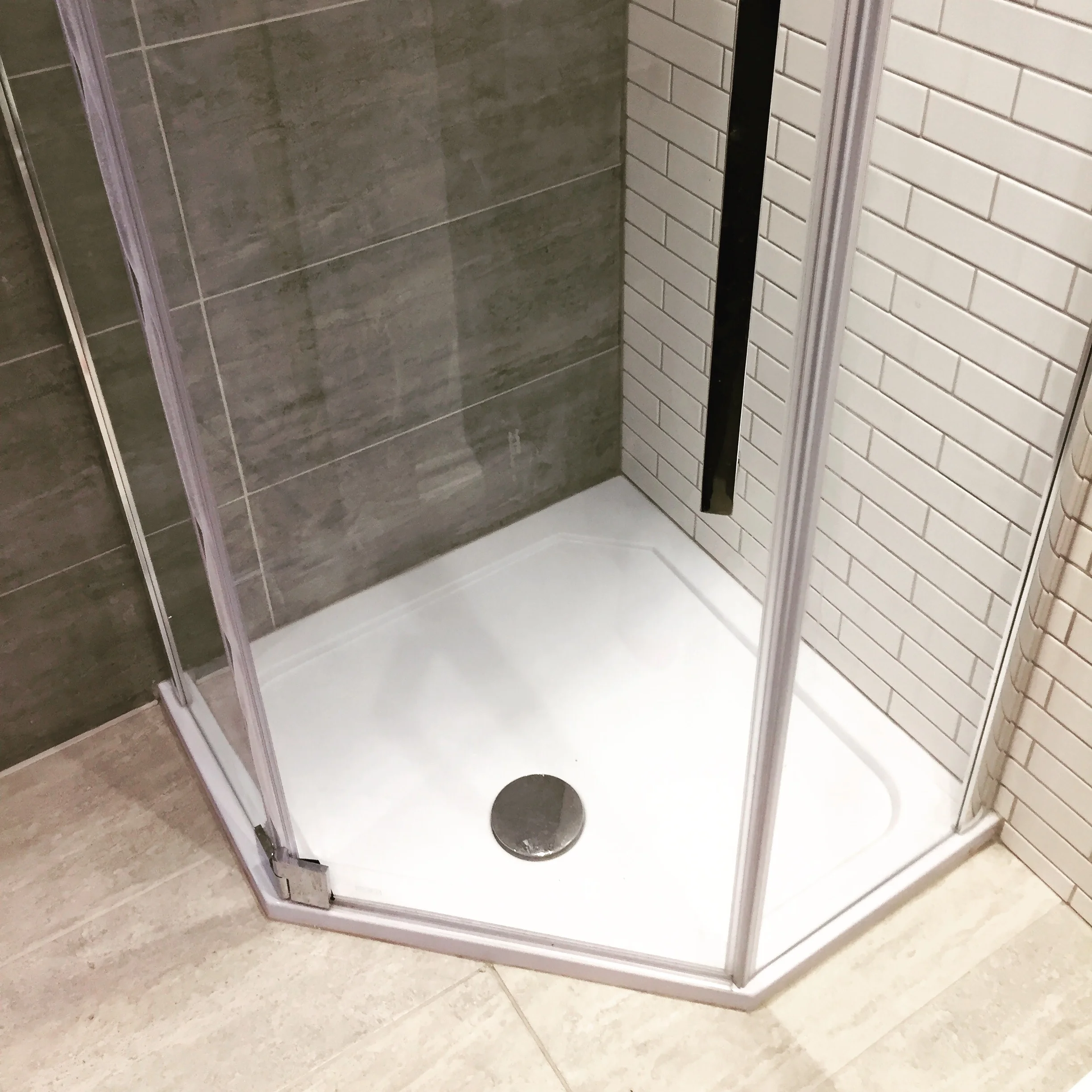   The shower room   A pentagonal shower allowed for a little extra space and looked great with the mixed greys/whites tile combination. 