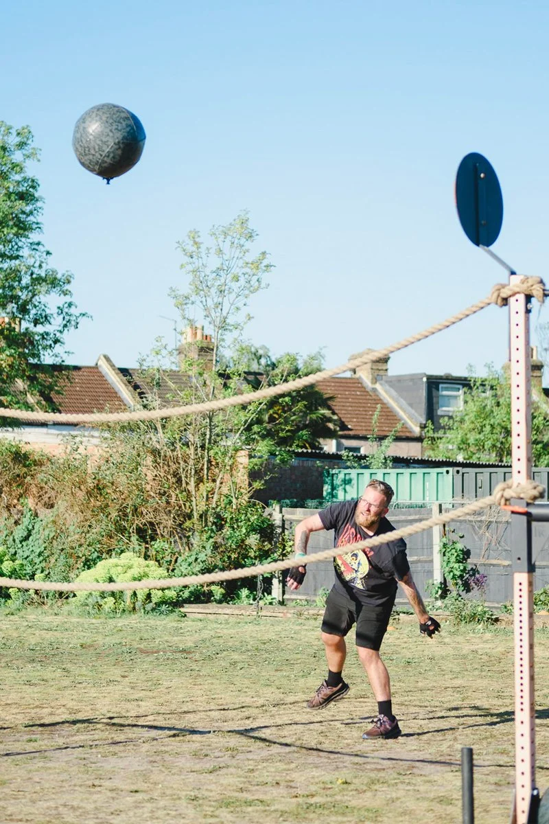 Man throws weighted medicine ball into the air outdoors