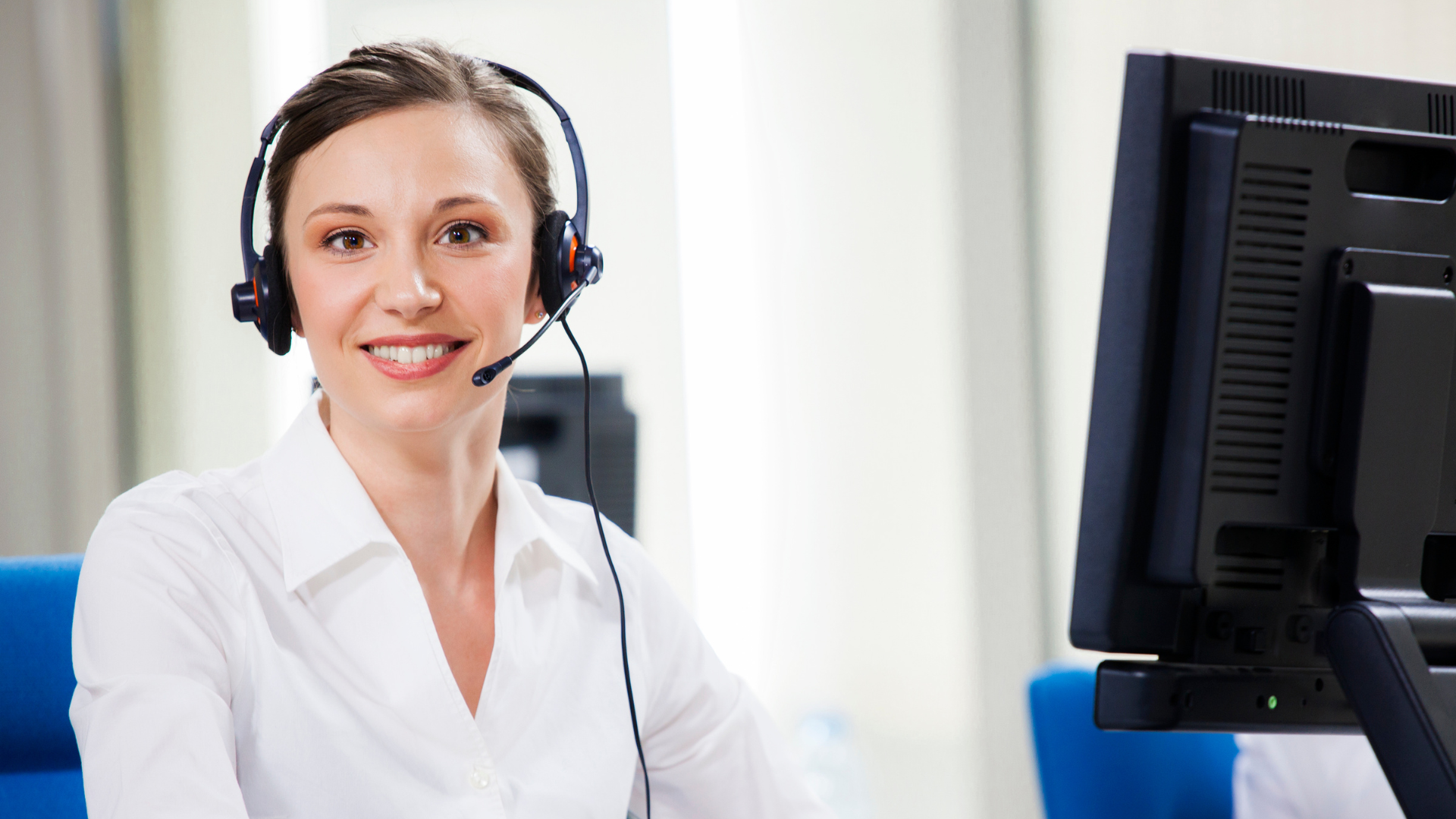 Donna con cuffie al computer in ufficio