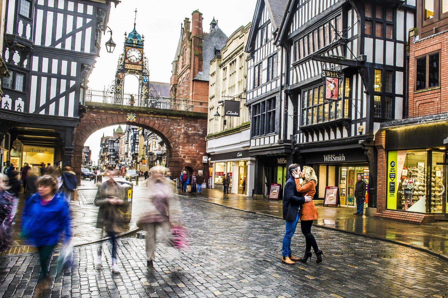 Man and woman kissing in busy Chester city centre