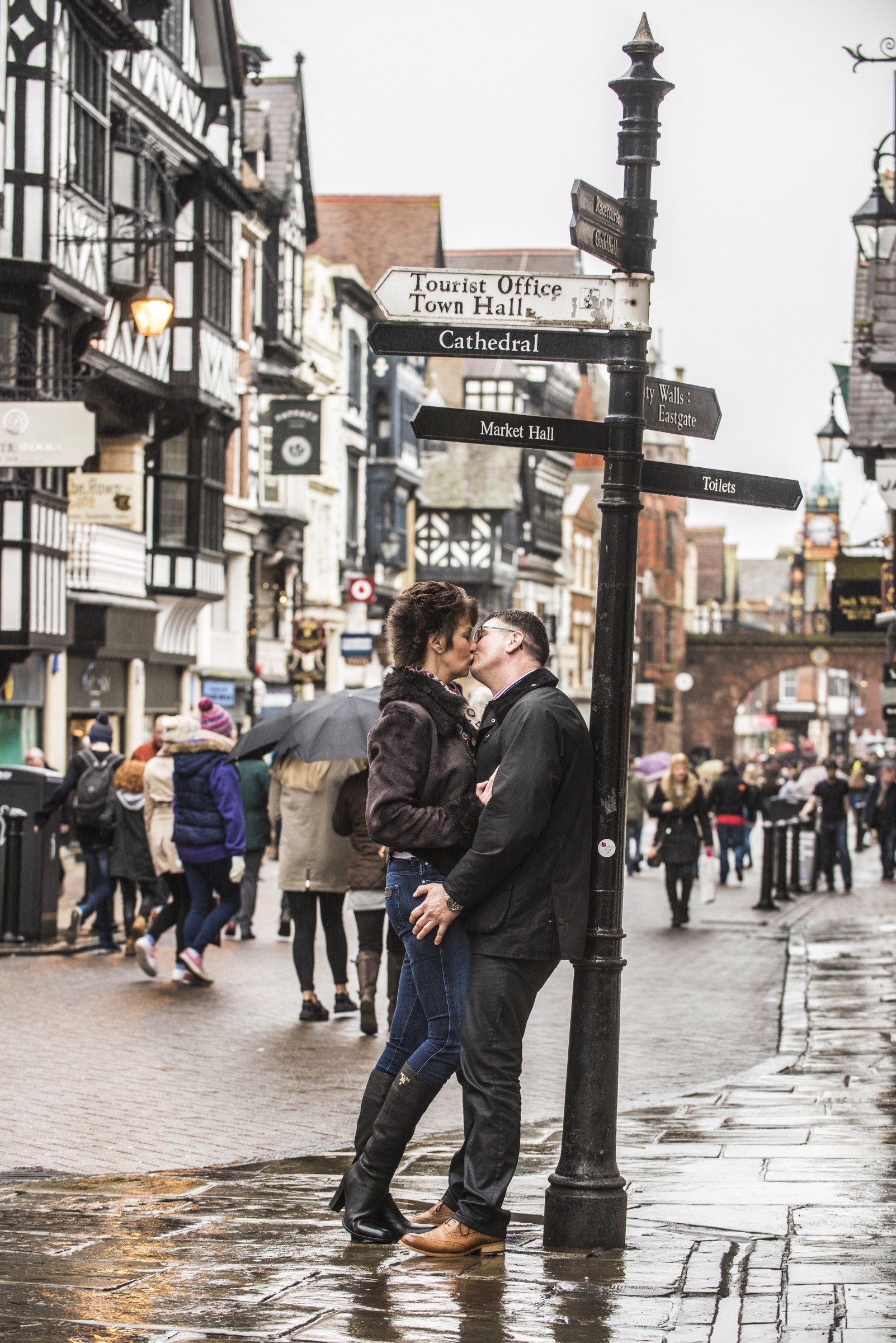 Man and woman kissing in busy Chester city centre