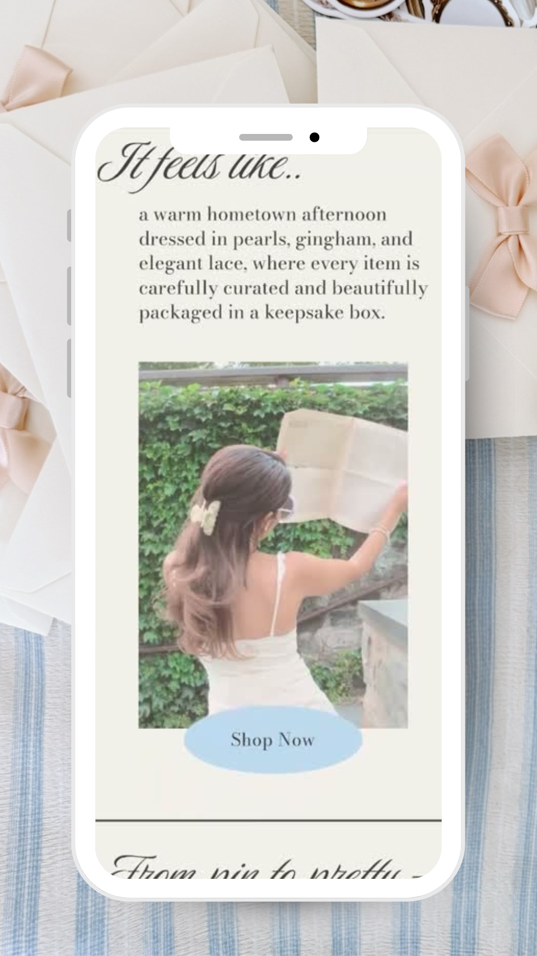 Mobile phone screen displaying a promotional message about a gift box with a woman reading outside. The message describes a cozy, elegant gift experience.