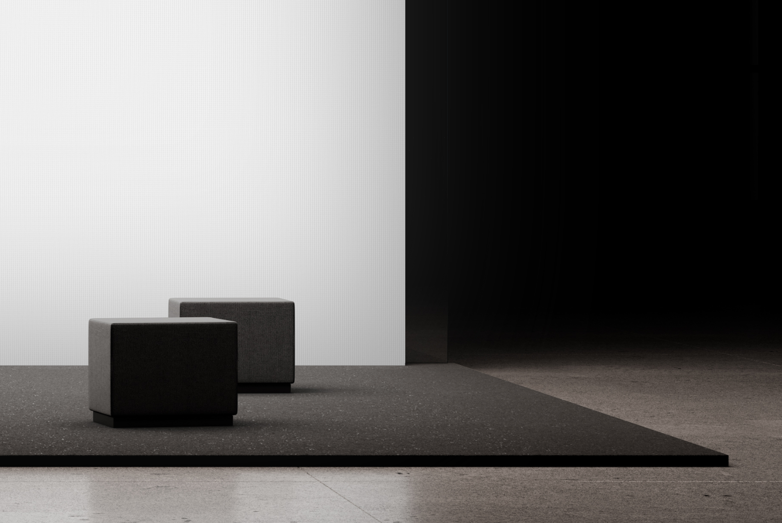 Close-up of two upholstered seating cubes on a minimalist exhibition stand