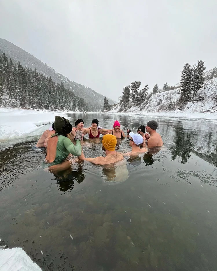 Small group immersed together in a snowy mountain river