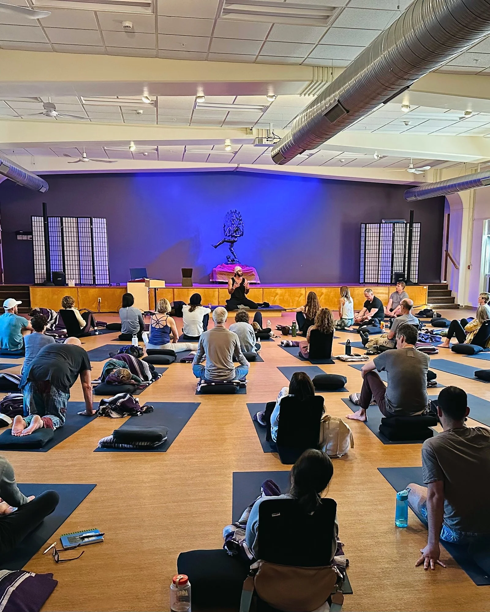 Samuel Whiting teaching a breathwork session in a full hall