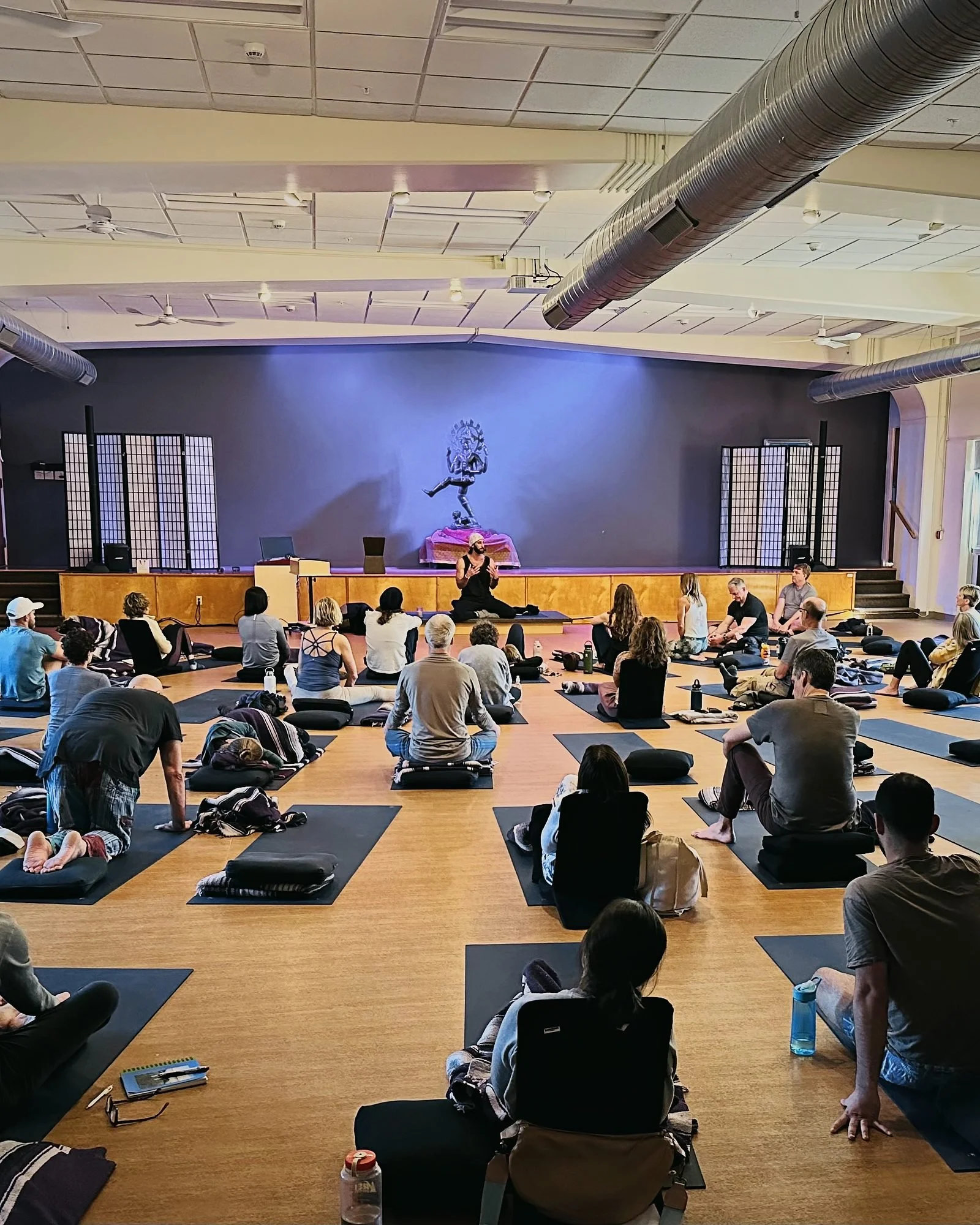 Samuel Whiting teaching a breathwork session in a full hall