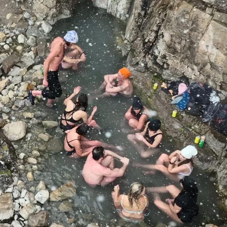 Group soaking together in a rocky natural hot spring