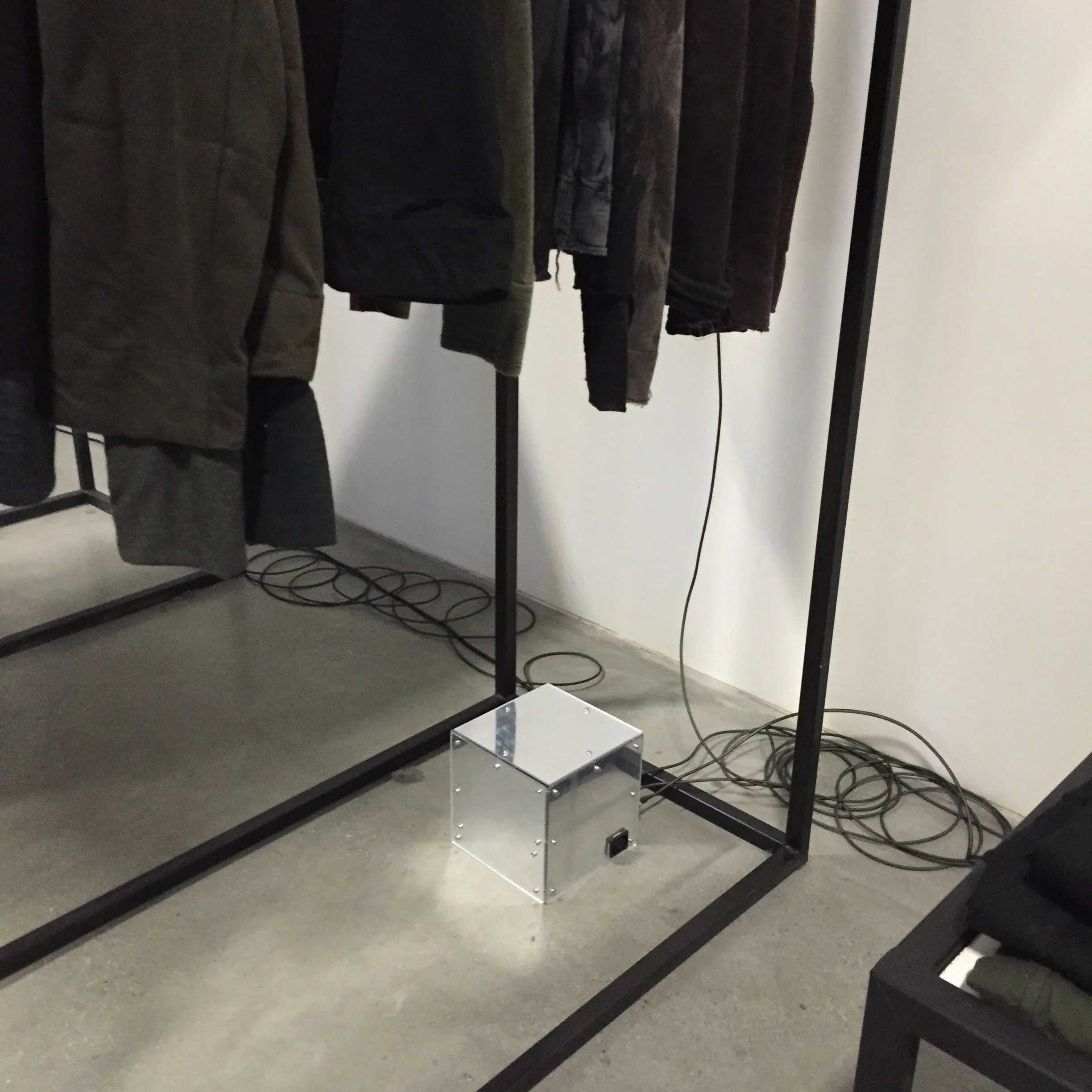Powered enclosure designed to illuminate garment racks
