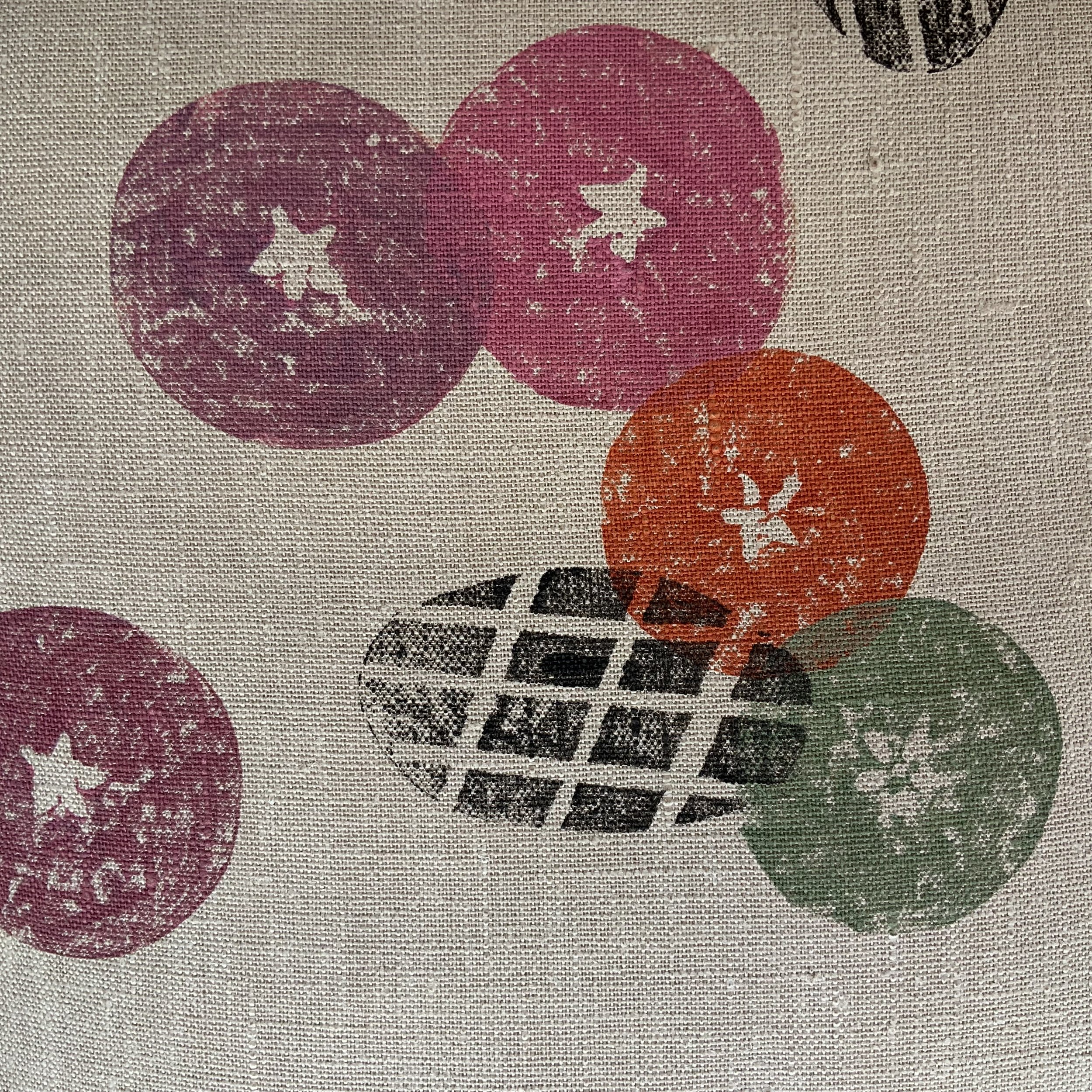 Hand-printed cushionin Devon by Susie Honnor using apples potatoes on 100%natural linen. A rich orange and red contrasts with a fresh green carefully over-printed with black. Detail.