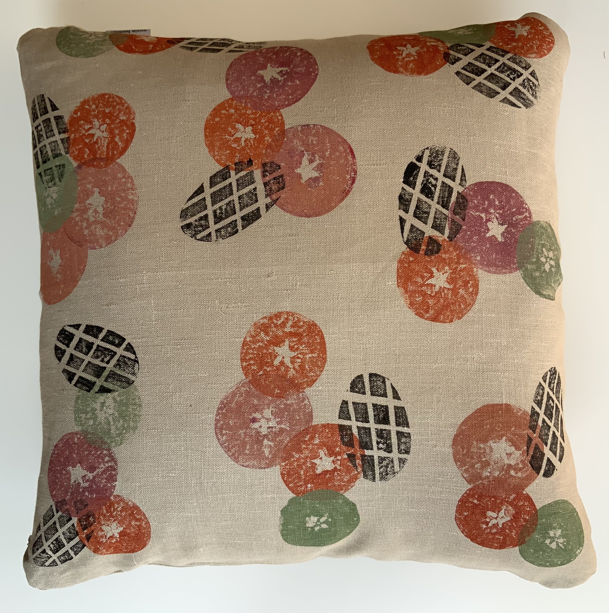 Hand-printed cushionin Devon by Susie Honnor using apples potatoes on 100%natural linen. A rich orange and red contrasts with a fresh green carefully over-printed with black. Back.