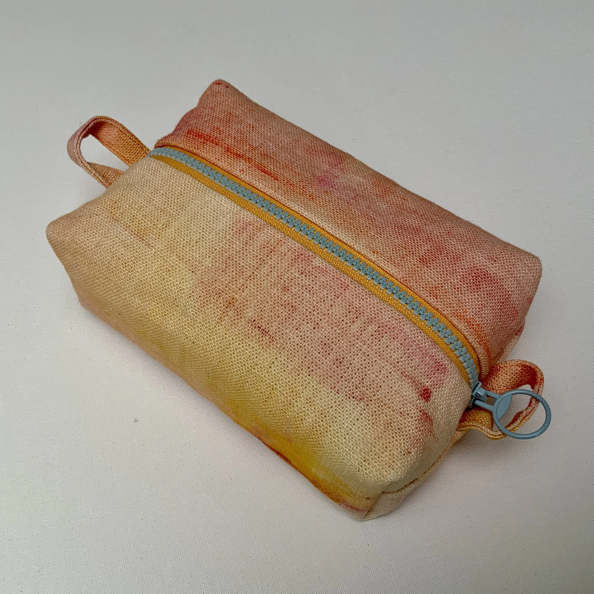 Hand printed boxy zipped pouch. Quality linen has been hand painted in pink hues. Fully lined and complete with contrasting feature zip.