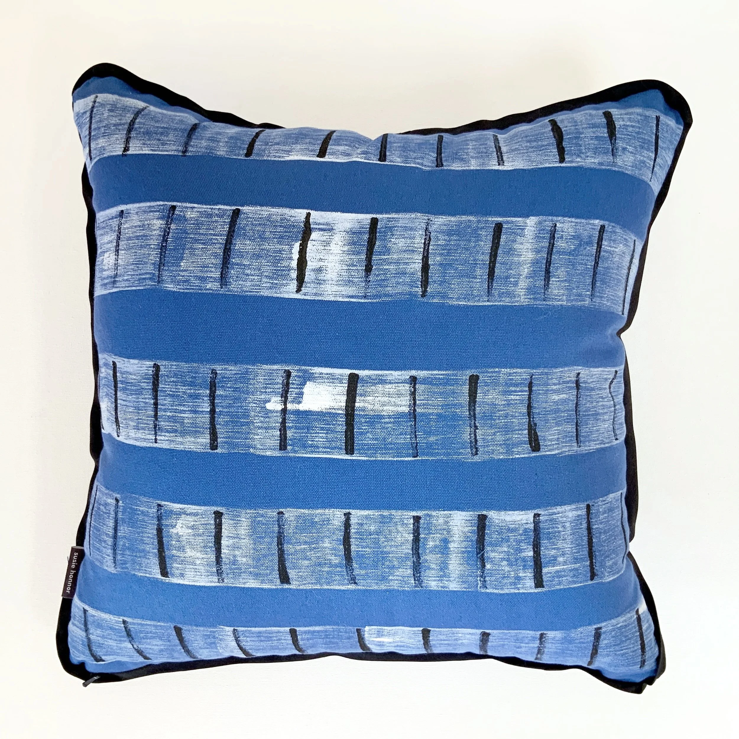 Hand printed cushion. Bold white brush strokes arranged symmetrically and accented with black marks contrast beautifully on the bright blue cotton fabric background.