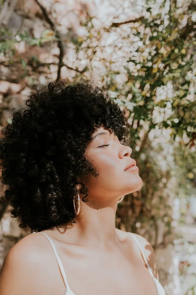 A woman outside with her eyes closed relaxing