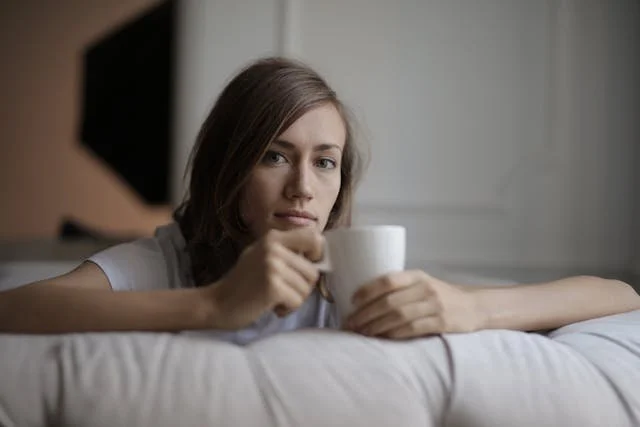 A woman sitting down with a coffee mug