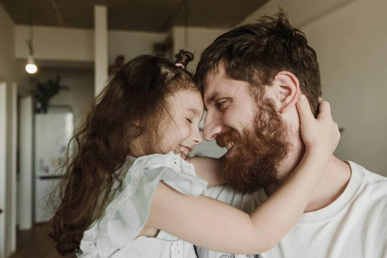 a happy child being carried by her father