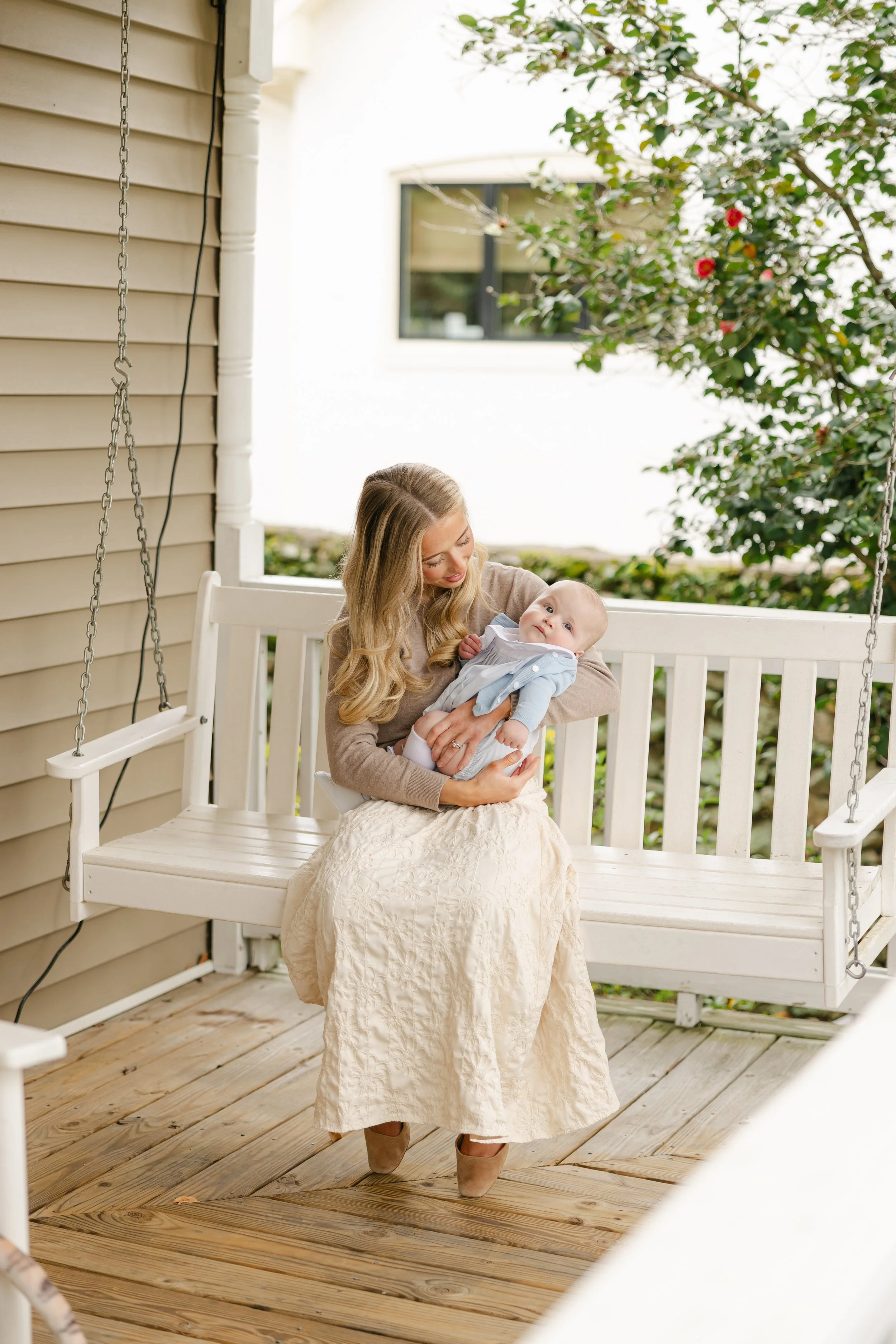 Parenting Student-Mom holding her newborn baby on a porch swing