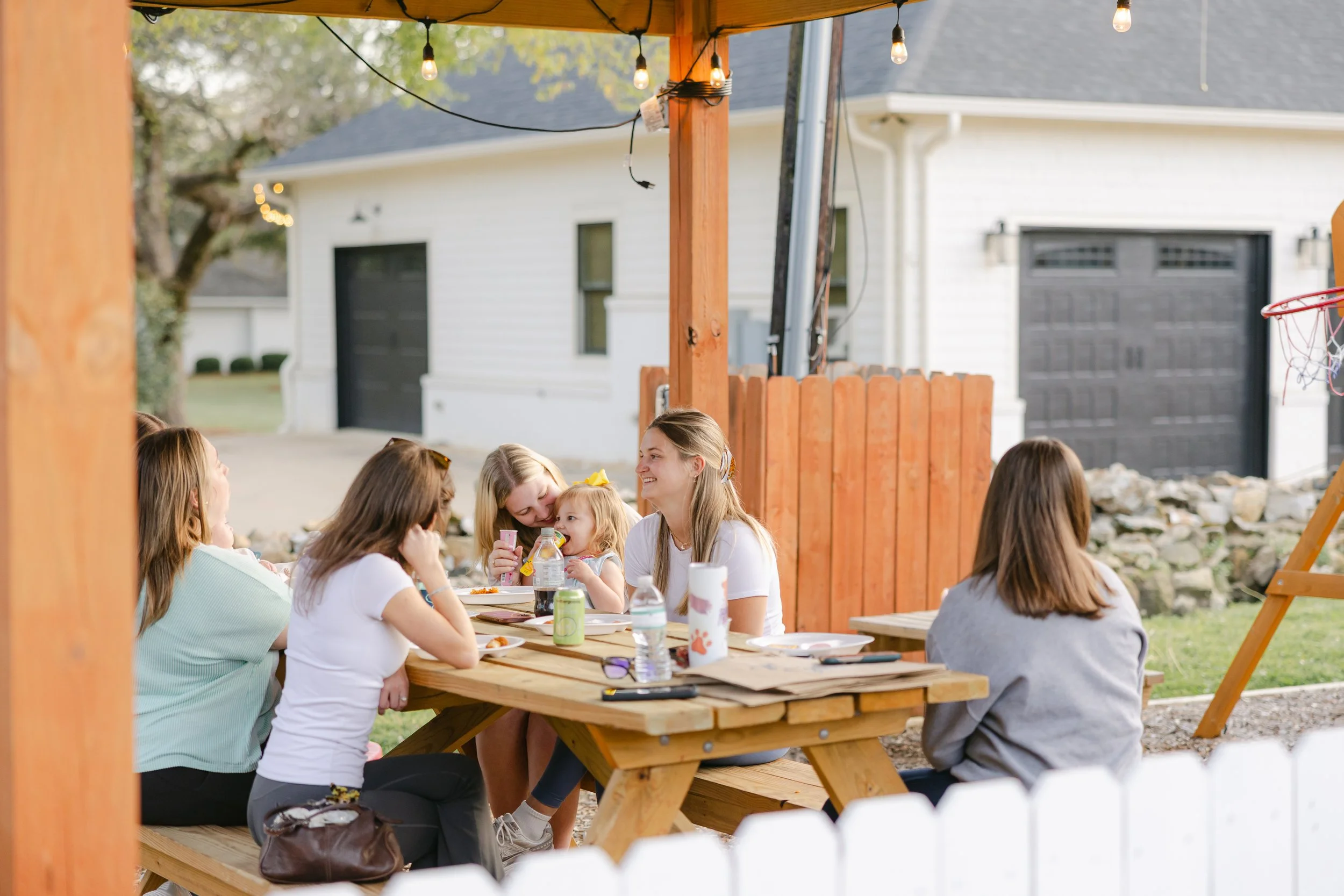 Student-Moms gathered around a picnic table enjoying community together