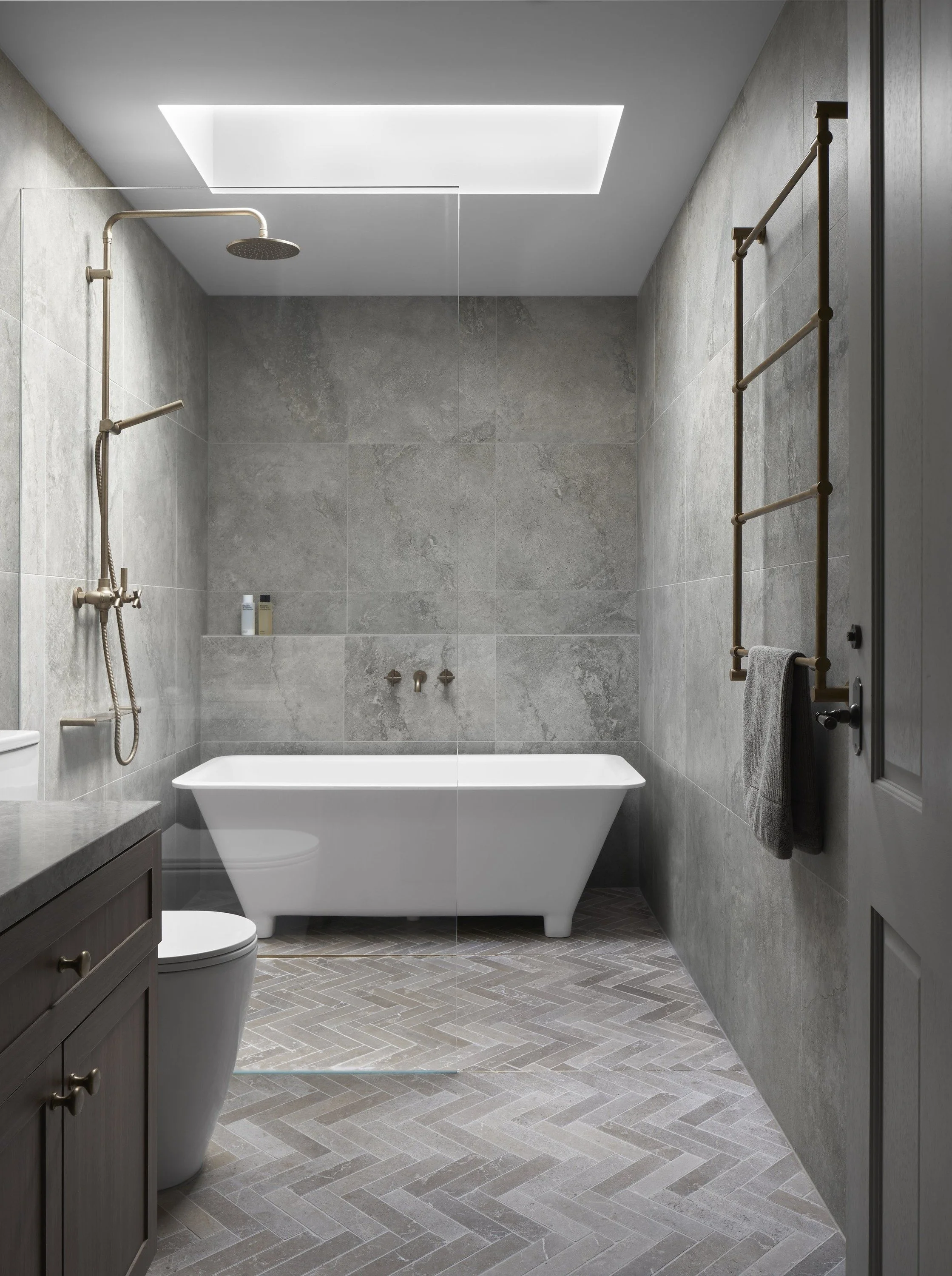 Richmond House bathroom with freestanding bath, herringbone floor tiles and skylight