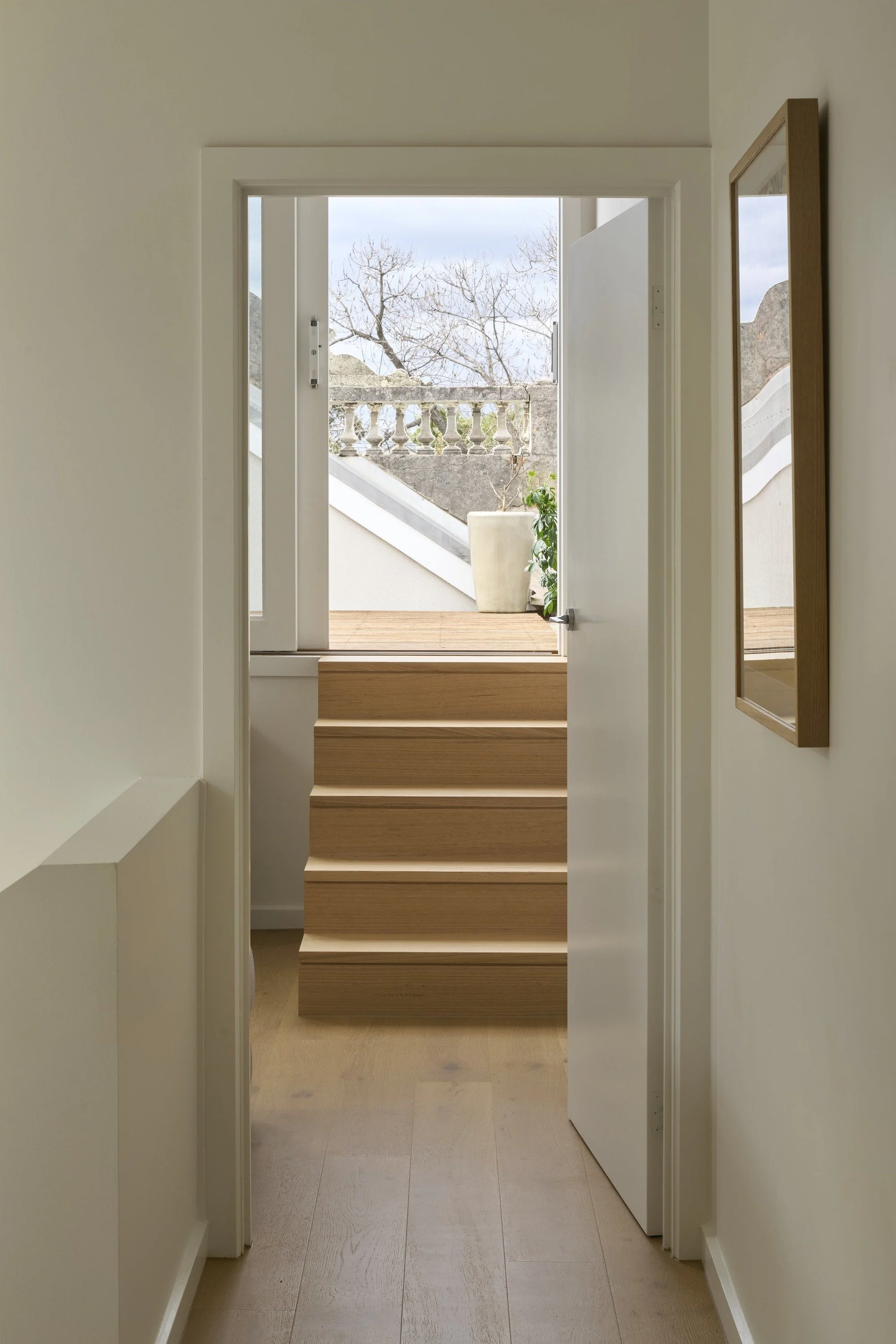 Carlton North House upstairs hallway with timber steps up to an outdoor terrace