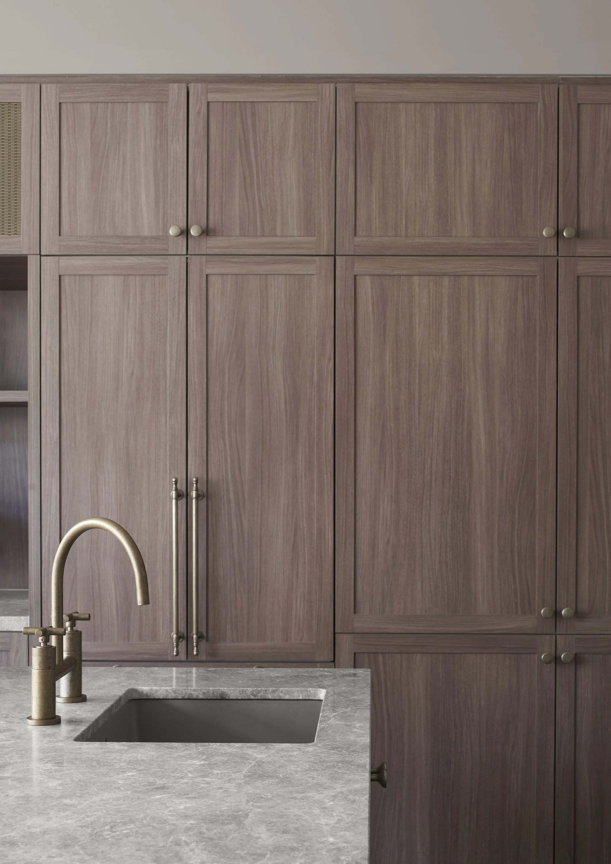 Richmond House kitchen sink with gold-toned tap, stone benchtop and timber cabinetry