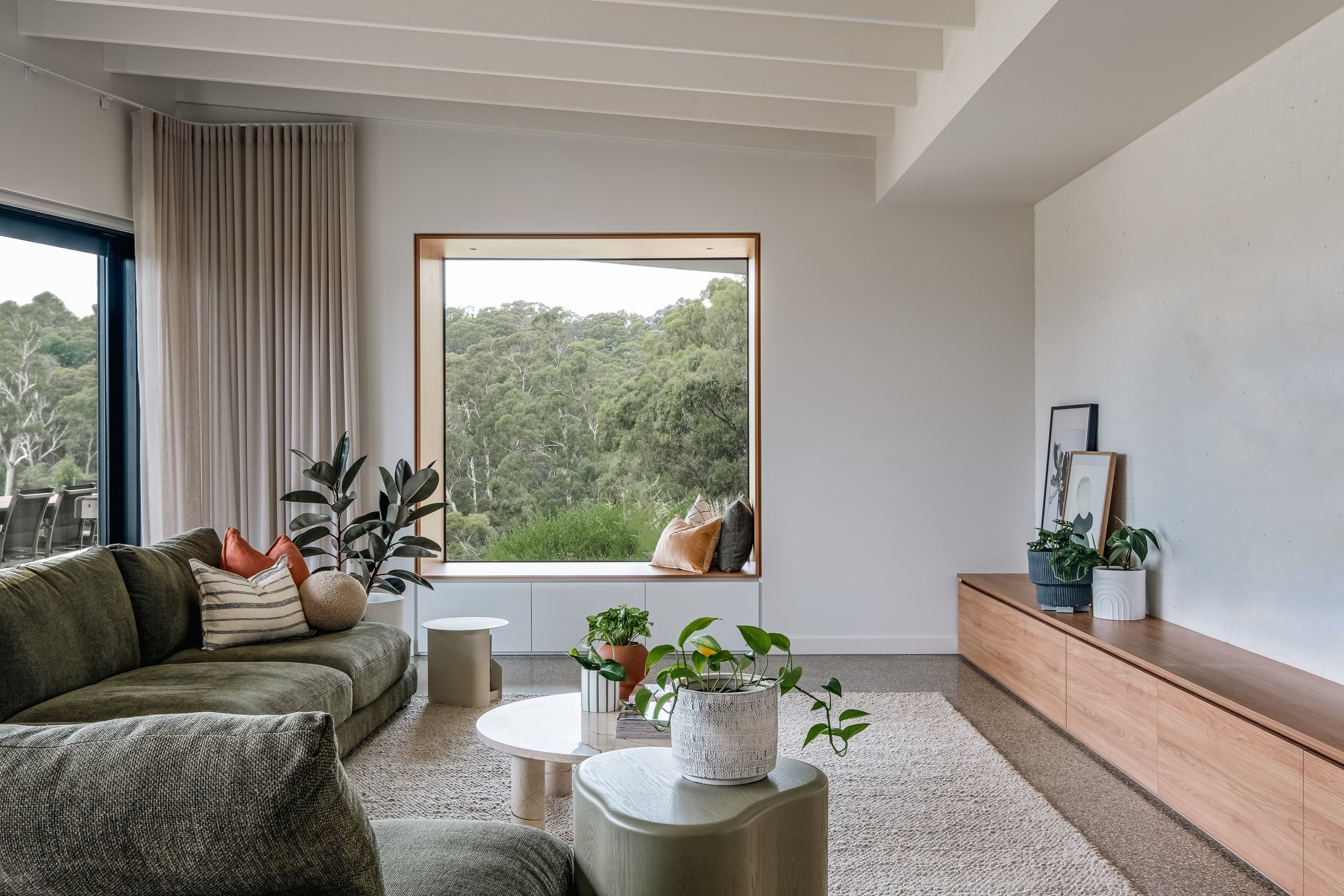 Donvale House living room with window seat framing bush views