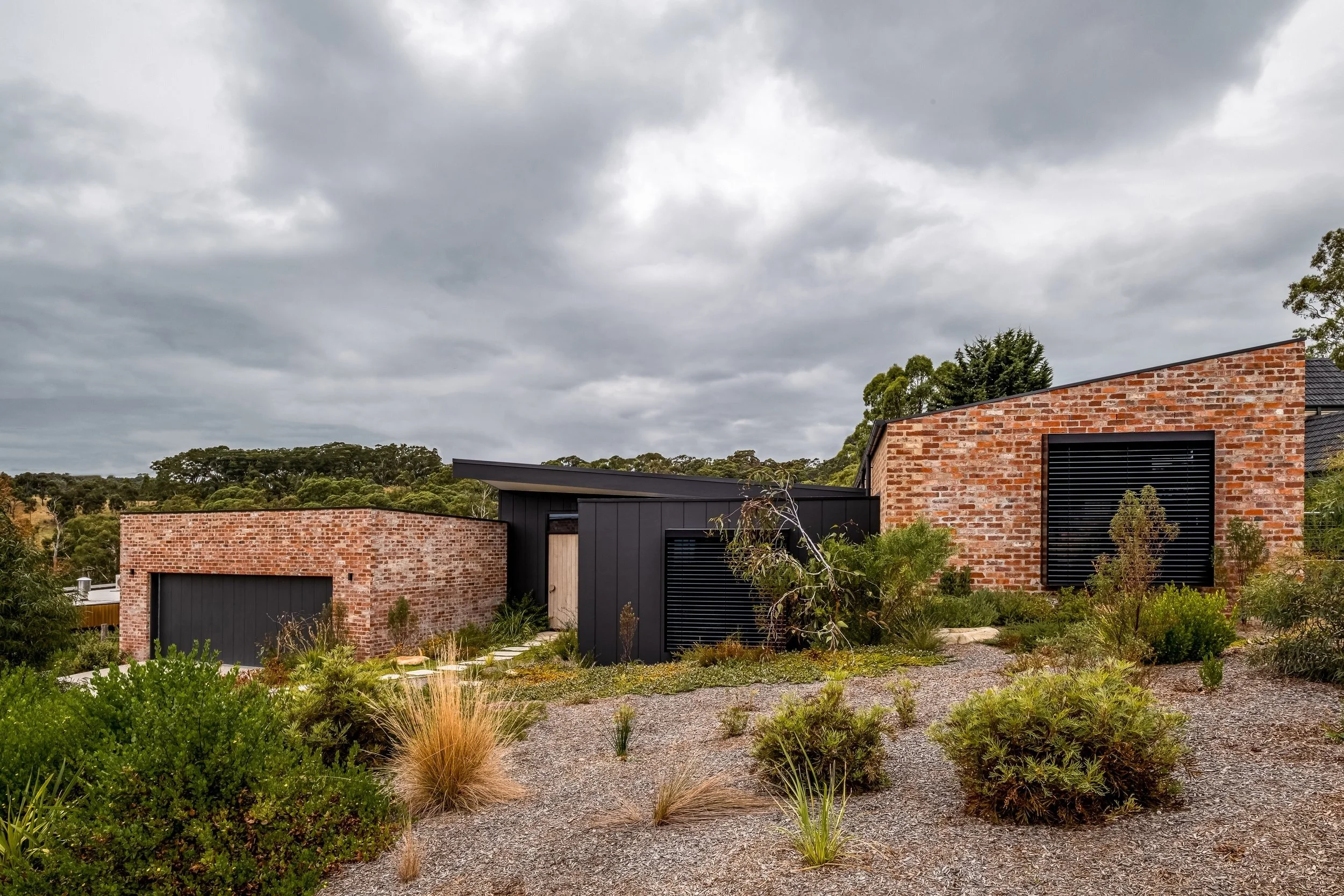 Donvale House red brick and black-clad pavilions in a gravel garden