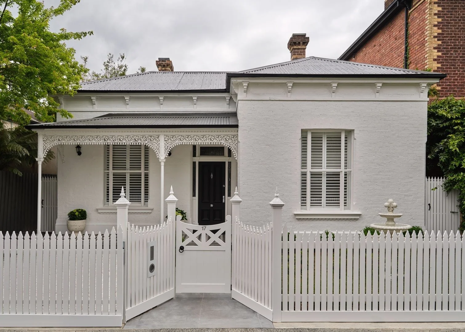 Windsor House Victorian facade with white picket fence and lacework verandah