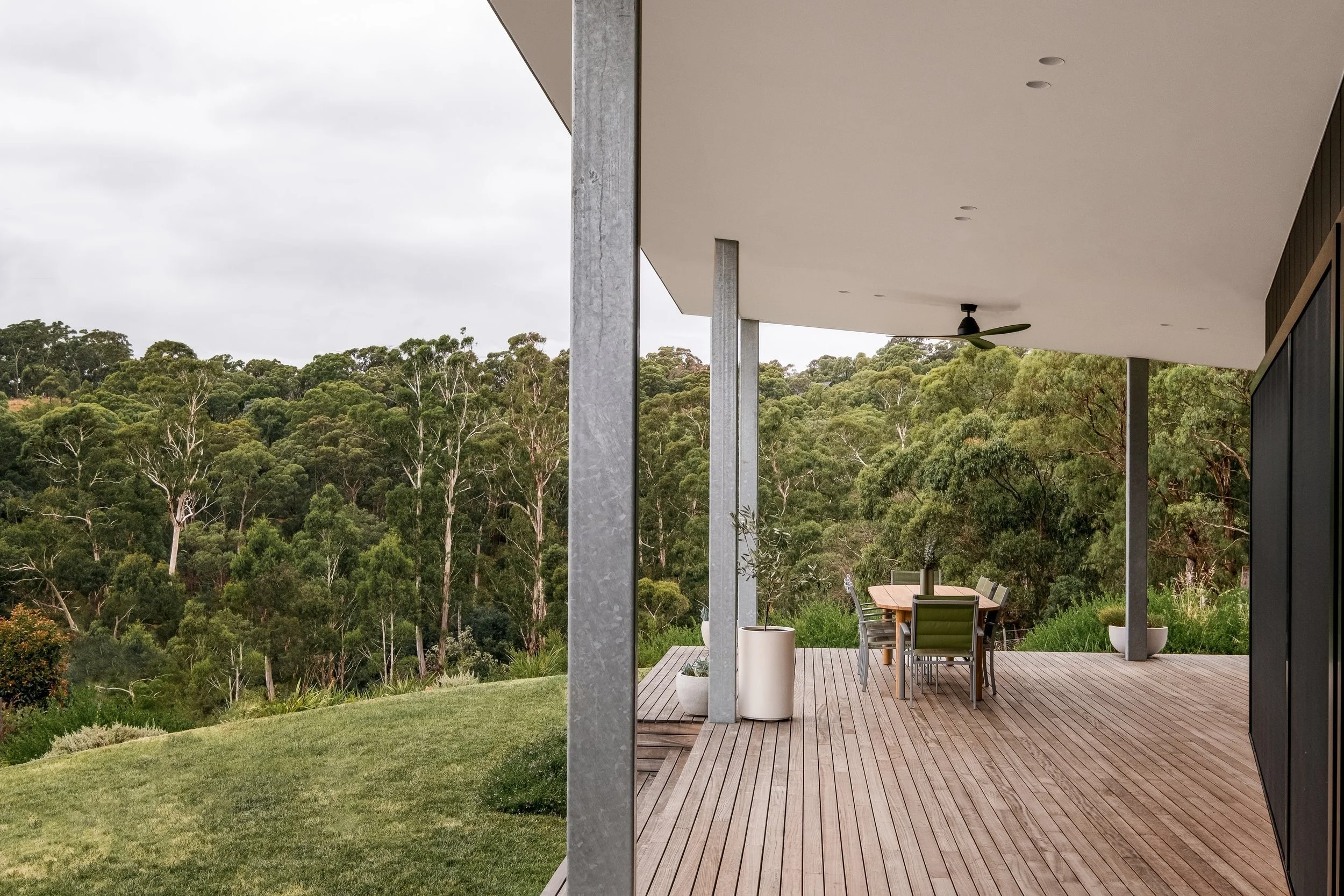 Donvale House covered timber deck with dining table overlooking bushland