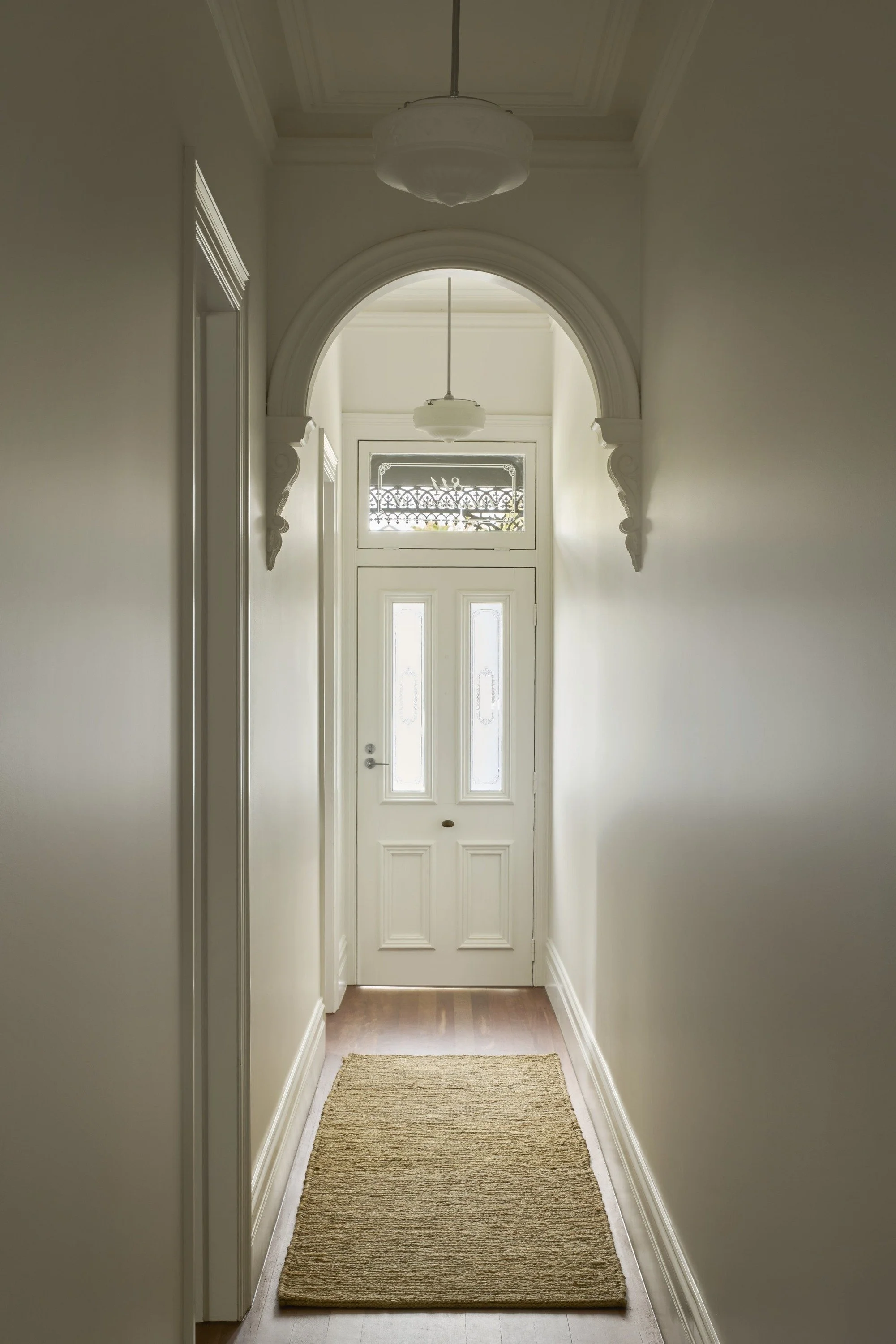 Carlton North House hallway with decorative archway leading to the front door