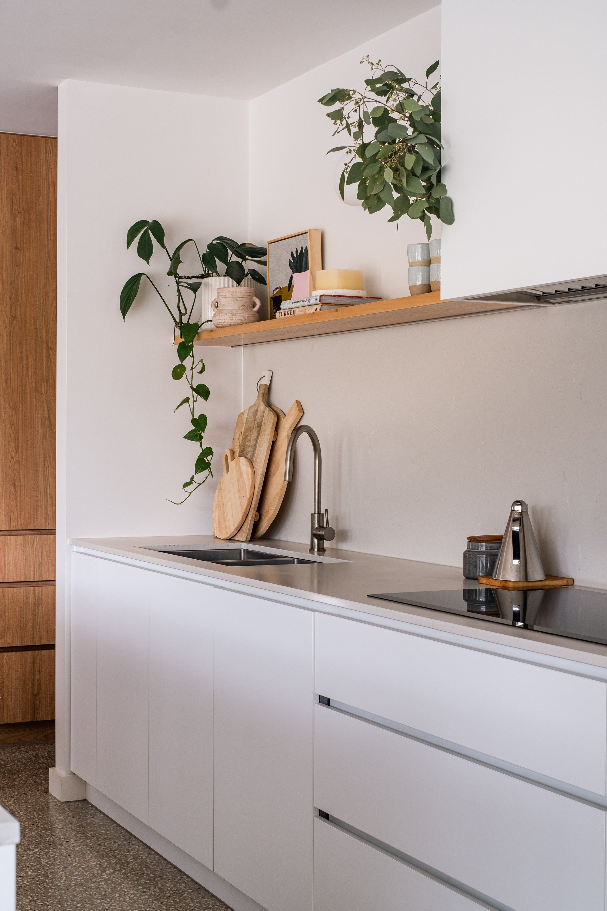 Donvale House kitchen with white cabinetry and timber floating shelf