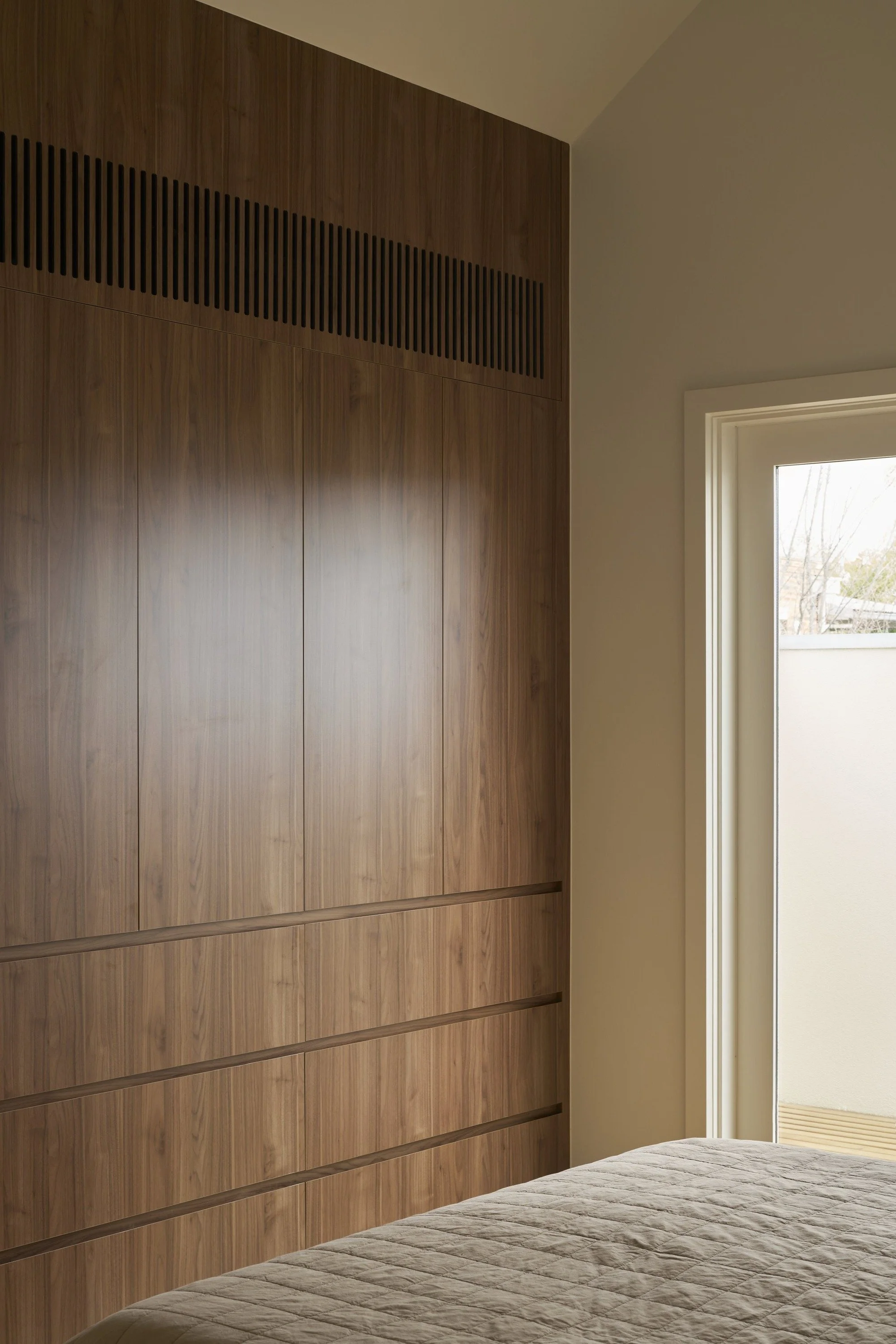 Carlton North House bedroom with full-height timber wardrobe