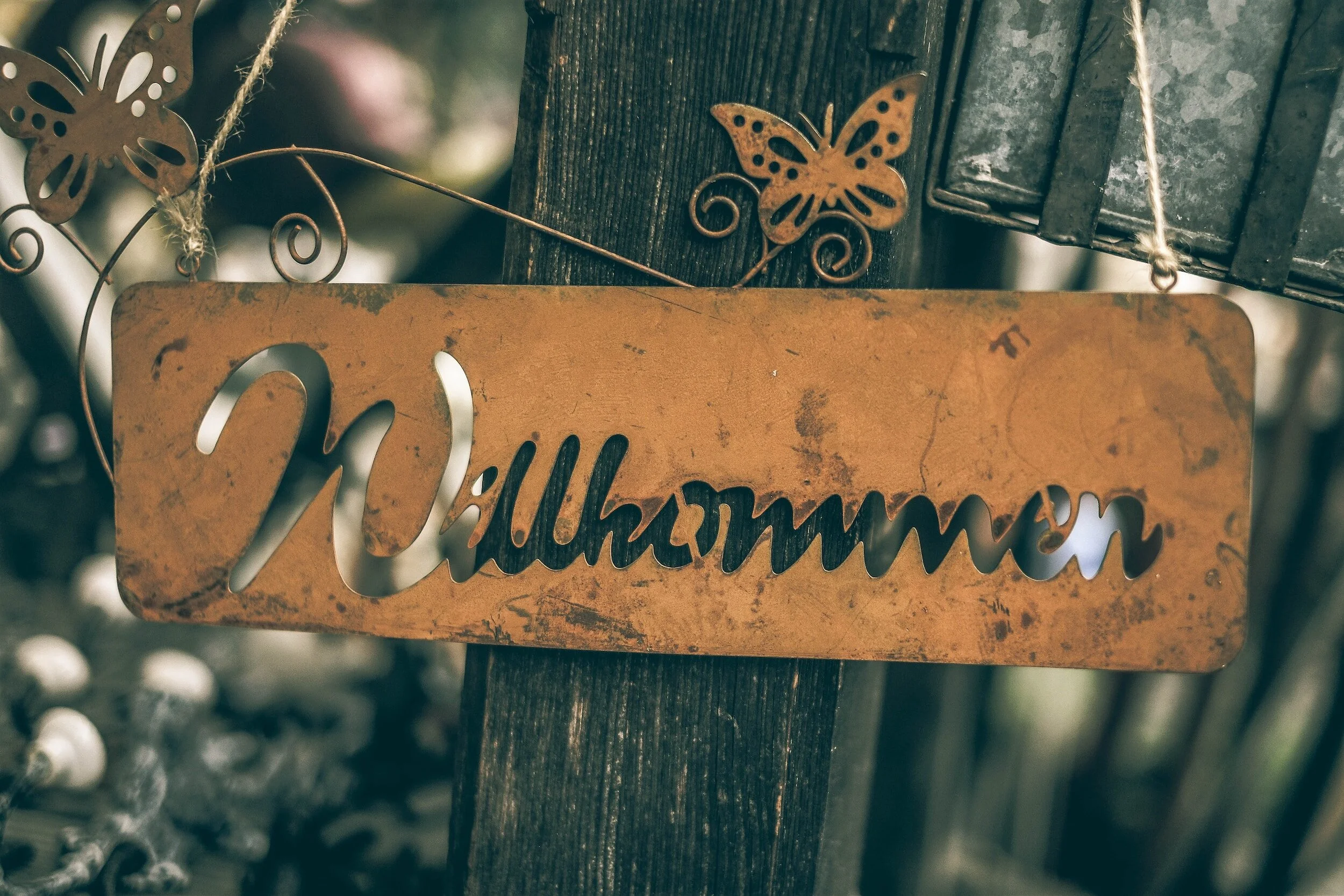 A metal sign which says "Willkoommen", which means "Welcome" in English.