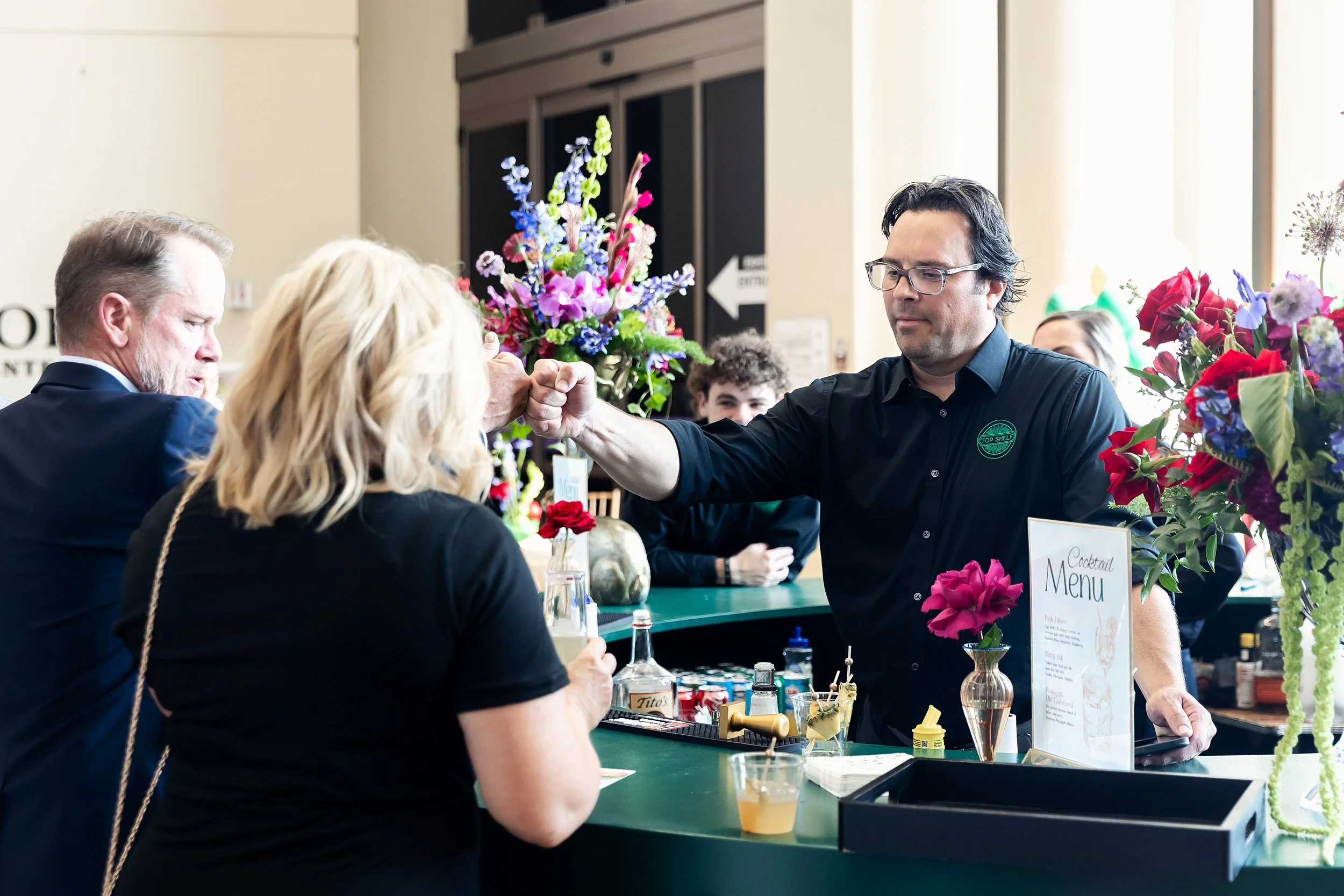Top Shelf bartender serving guests at an elevated cocktail experience in Oklahoma City.
