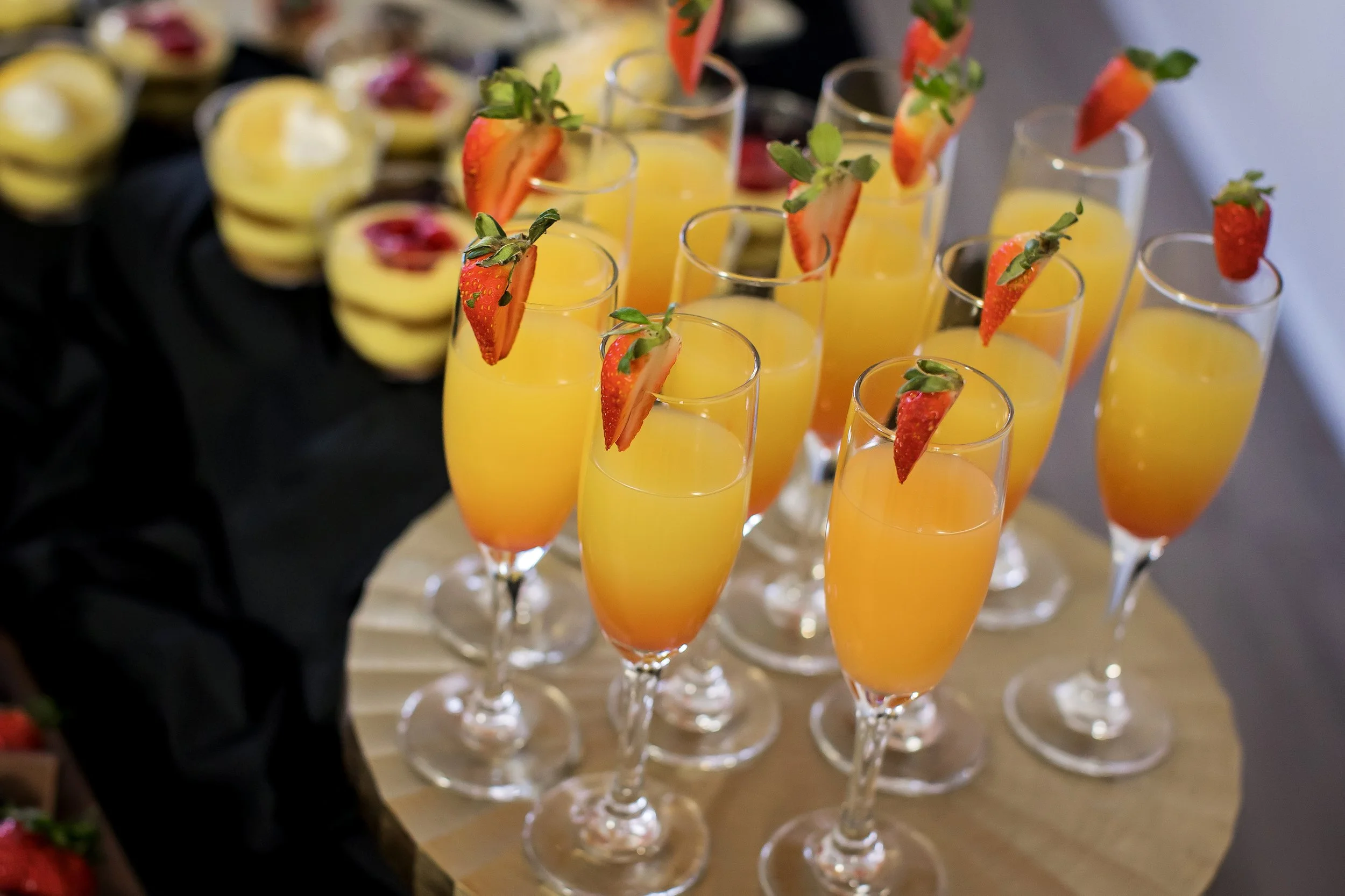 Champagne cocktails with strawberry garnish prepared for a catered event by Top Shelf Cuisine & Cocktails